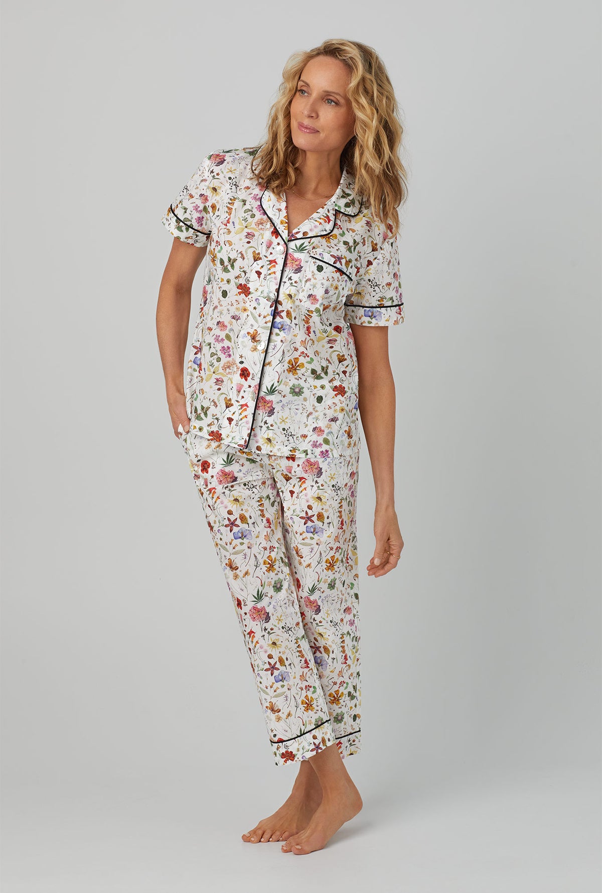 A lady wearing short sleeve classic cropped pj set with floral eve print