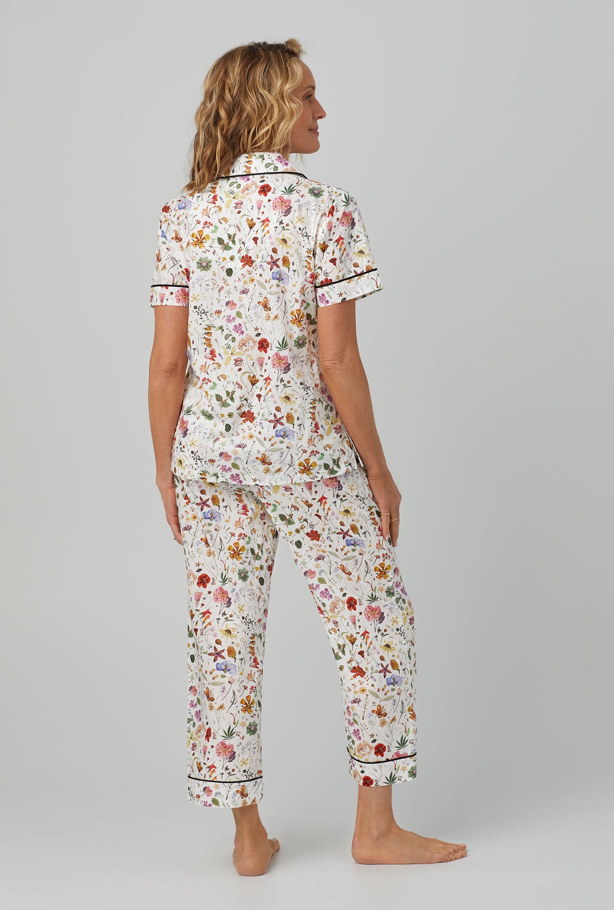 A lady wearing short sleeve classic cropped pj set with floral eve print