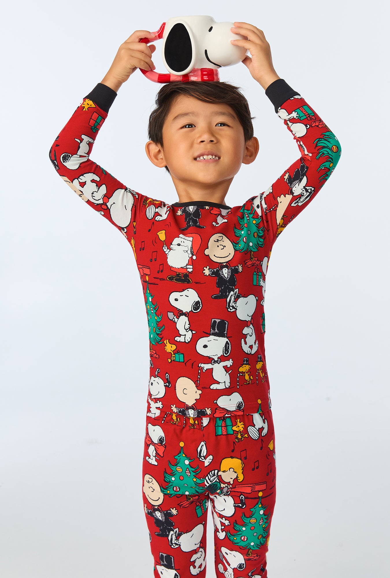 A child wearing Peanuts® Festive Fun Long Sleeve Stretch Jersey Kids PJ Set