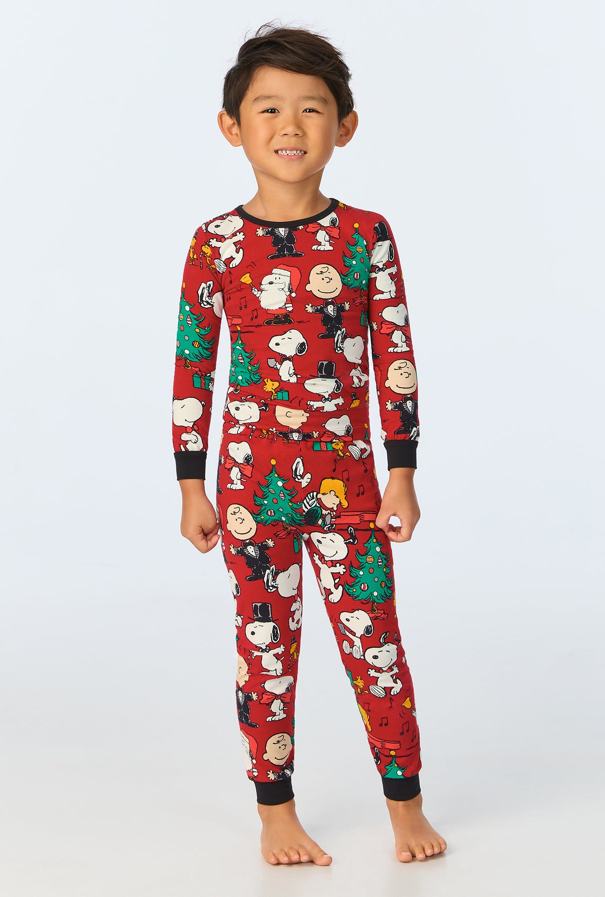 A child wearing Peanuts® Festive Fun Long Sleeve Stretch Jersey Kids PJ Set