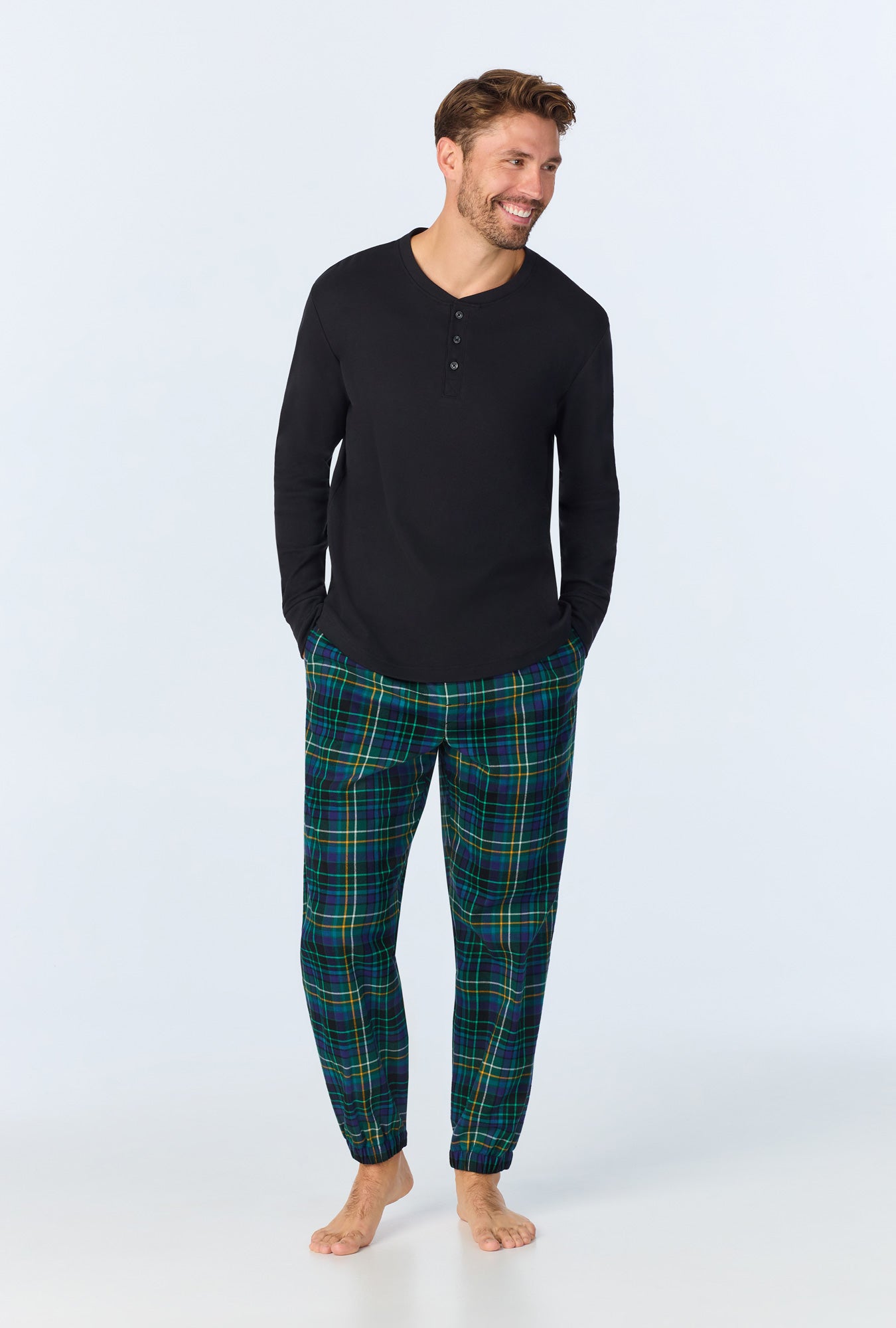 A man wearing Celebration Plaid Men's Long Sleeve Henley and Jogger Woven Portuguese Flannel  PJ Set