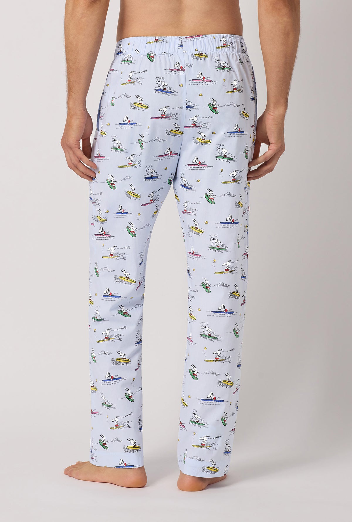 A man wearing Catch A Wave, Snoopy Men's Woven Cotton Poplin Pj Pant back view