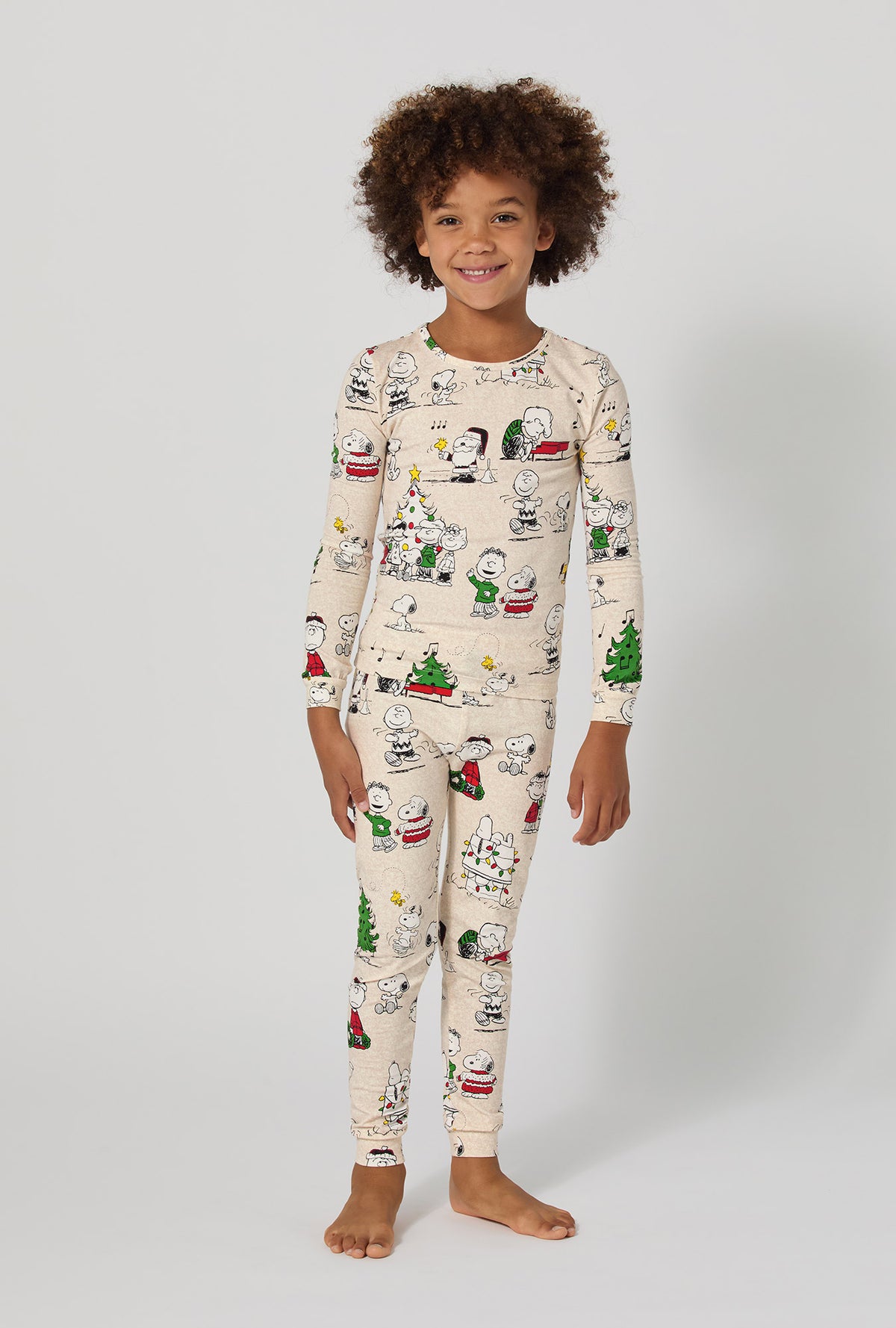 A boy wearing Peanuts® Celebration Long Sleeve Stretch Jersey Kids Pj Set