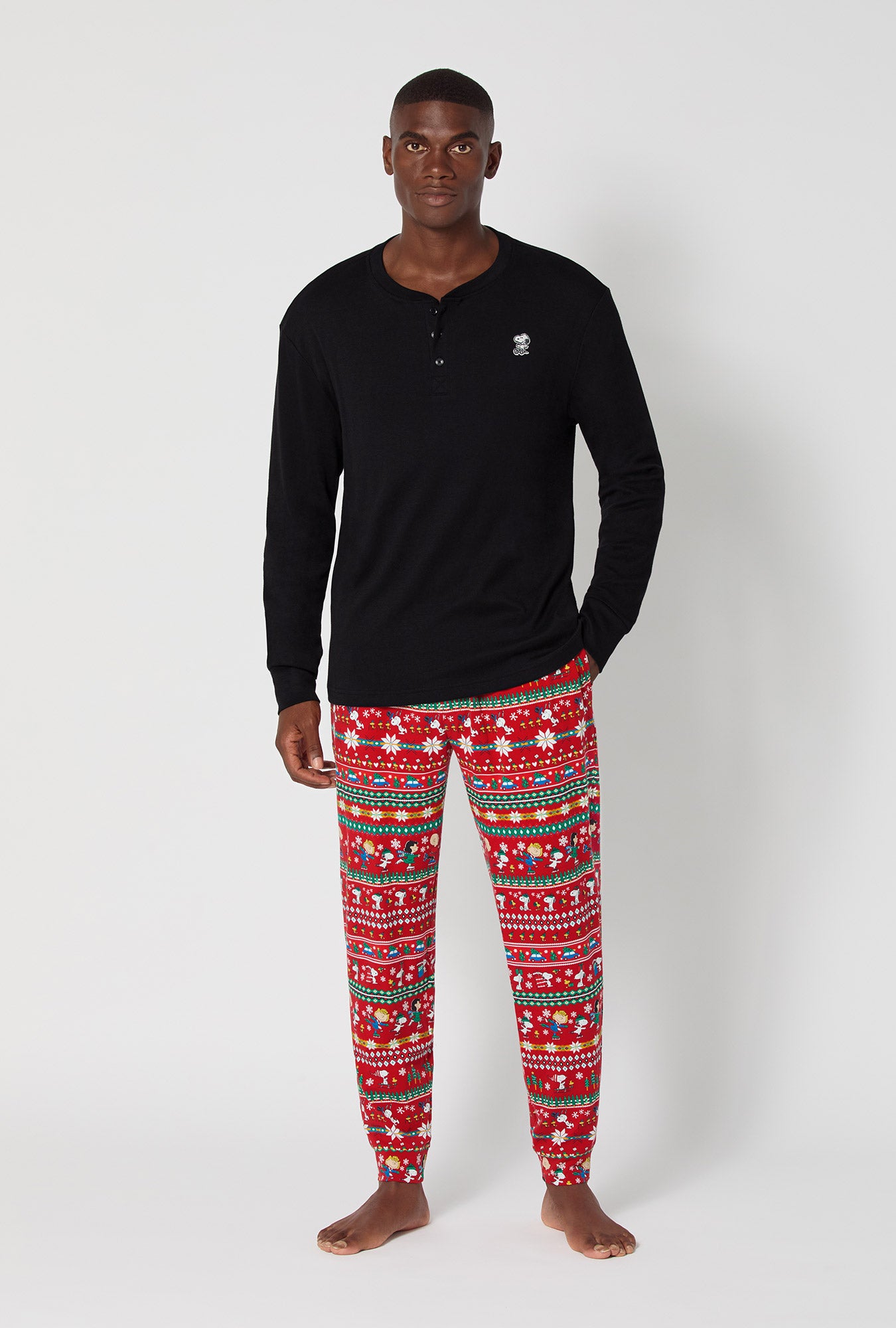 A man wearing Peanuts®  Winter Fairisle Men's Long Sleeve Henley And Jogger Stretch Jersey Pj Set