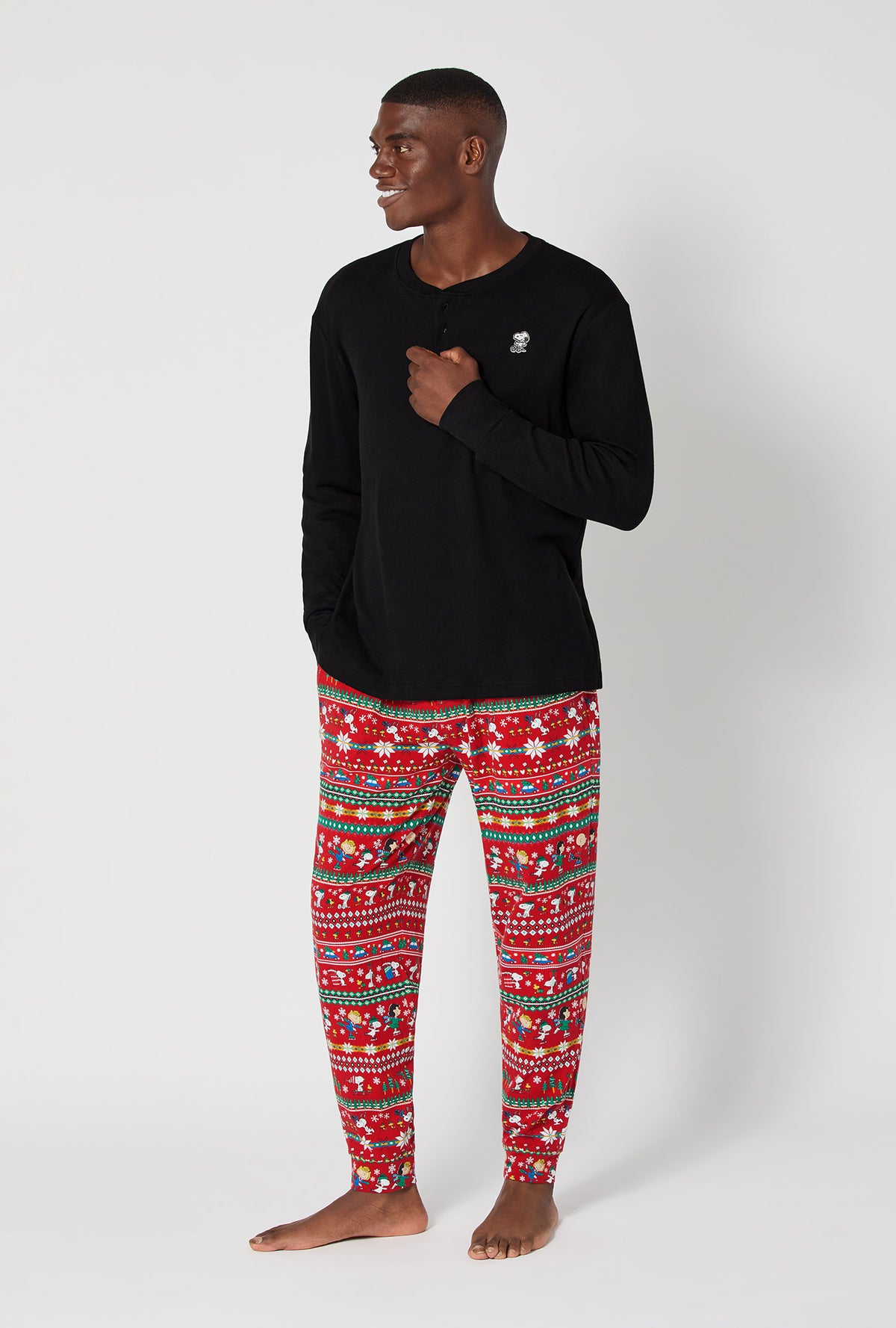 A man wearing Peanuts®  Winter Fairisle Men's Long Sleeve Henley And Jogger Stretch Jersey Pj Set