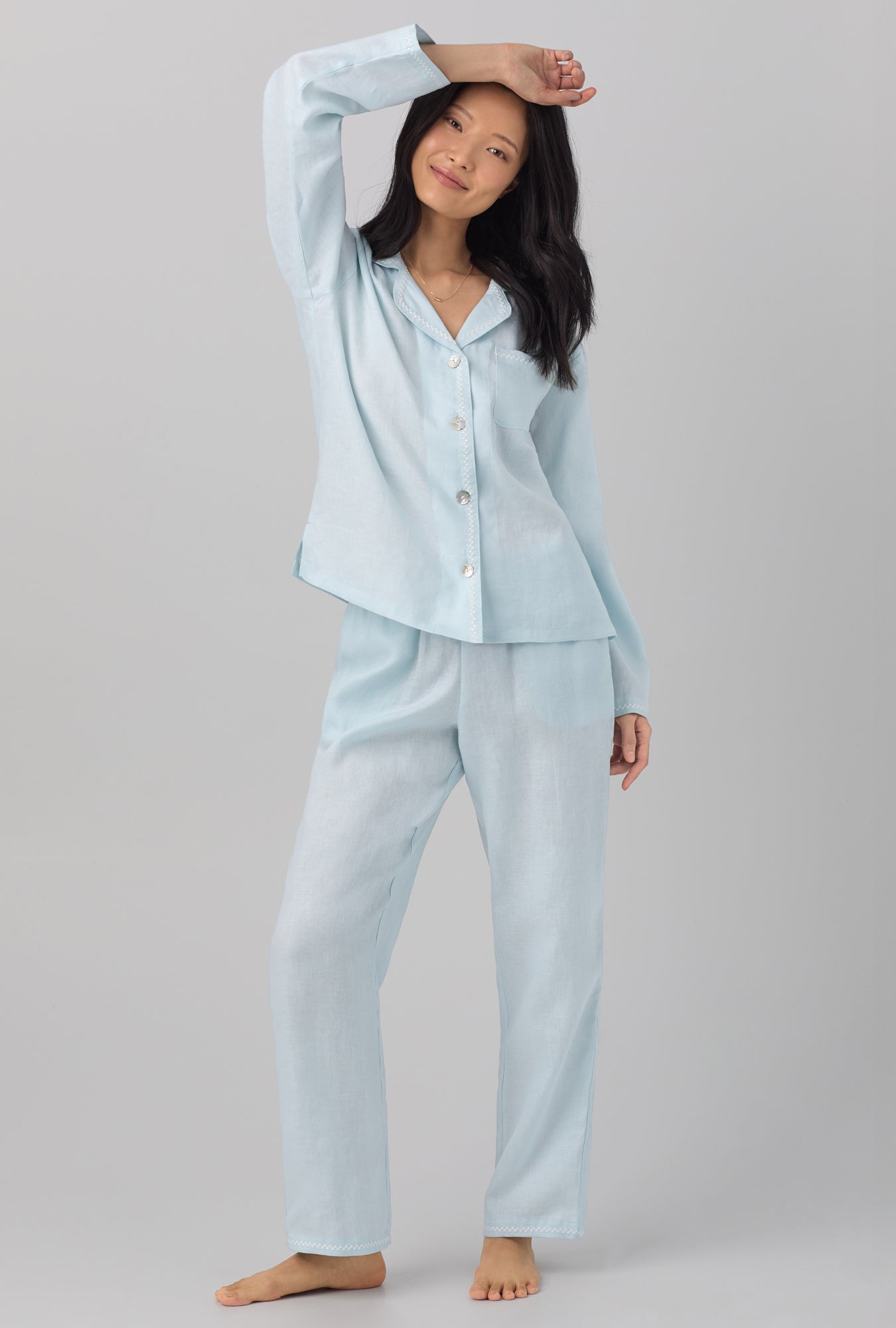 A lady wearing blue long sleeve classic linen pj set with delicate blue print.