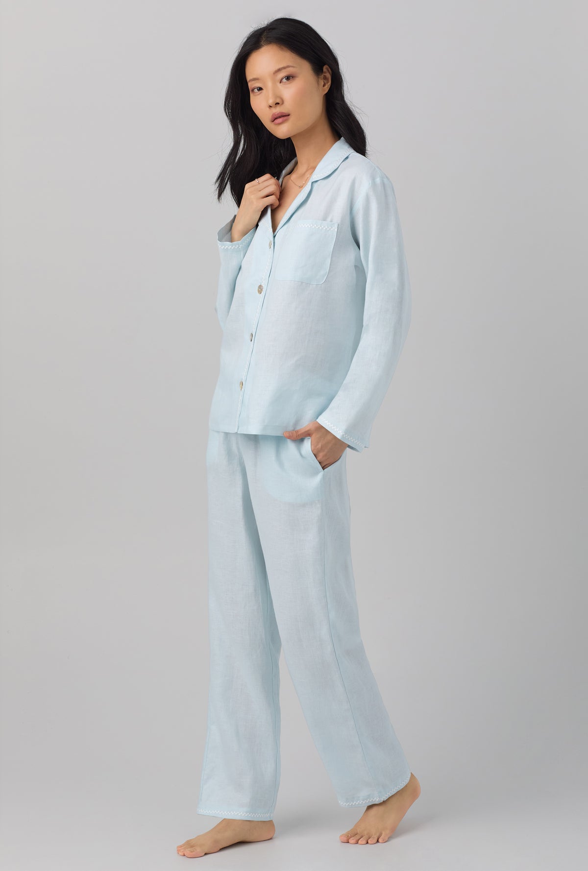 A lady wearing blue long sleeve classic linen pj set with delicate blue print.
