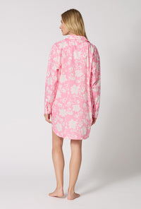 A Lady Wearing Dynasty Pink High Low Woven Cotton Poplin Boyfriend Shirt turned back pose while looking to the side