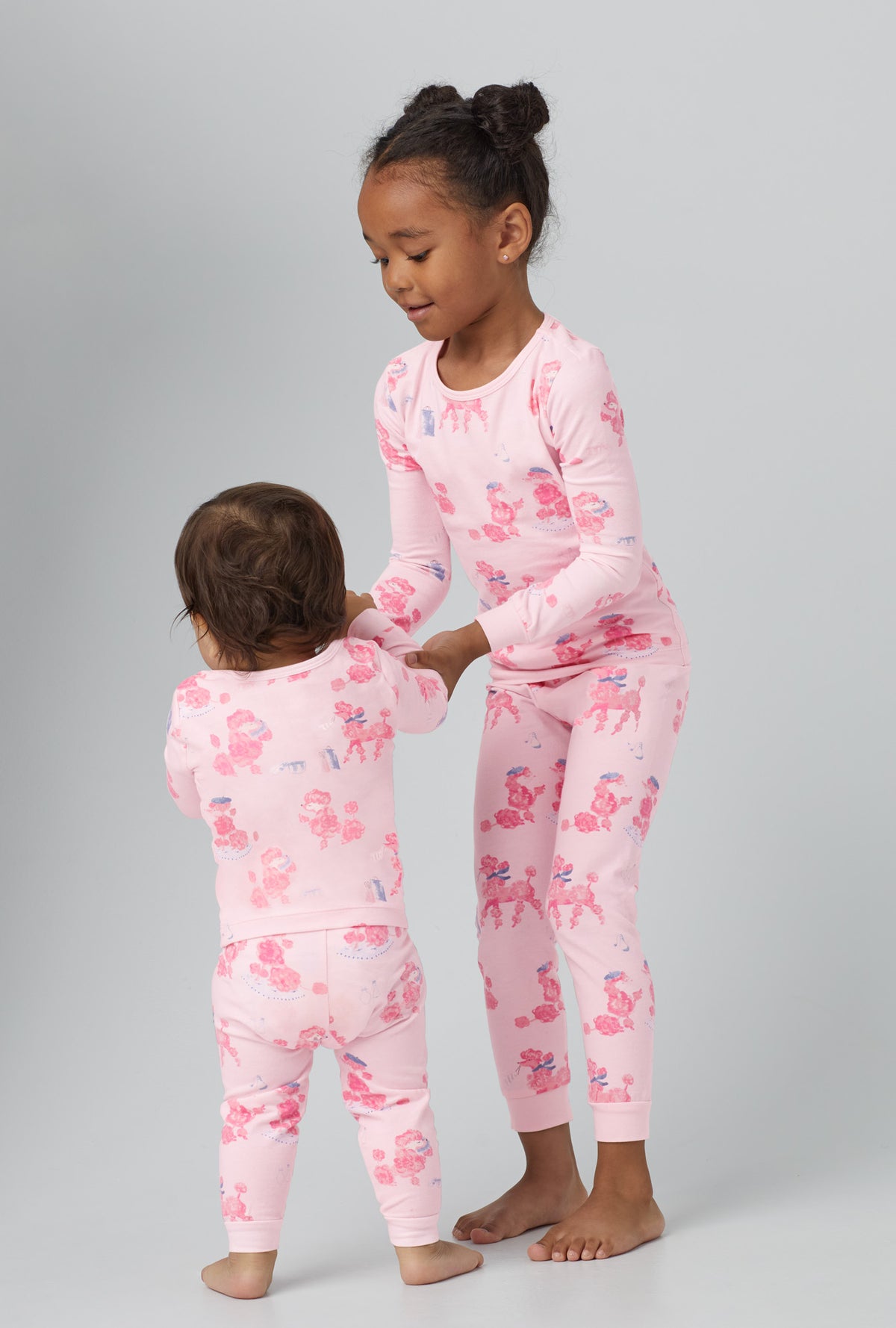 A girl wearing  Long Sleeve Stretch Jersey Kids PJ Set with pampered Poodles print