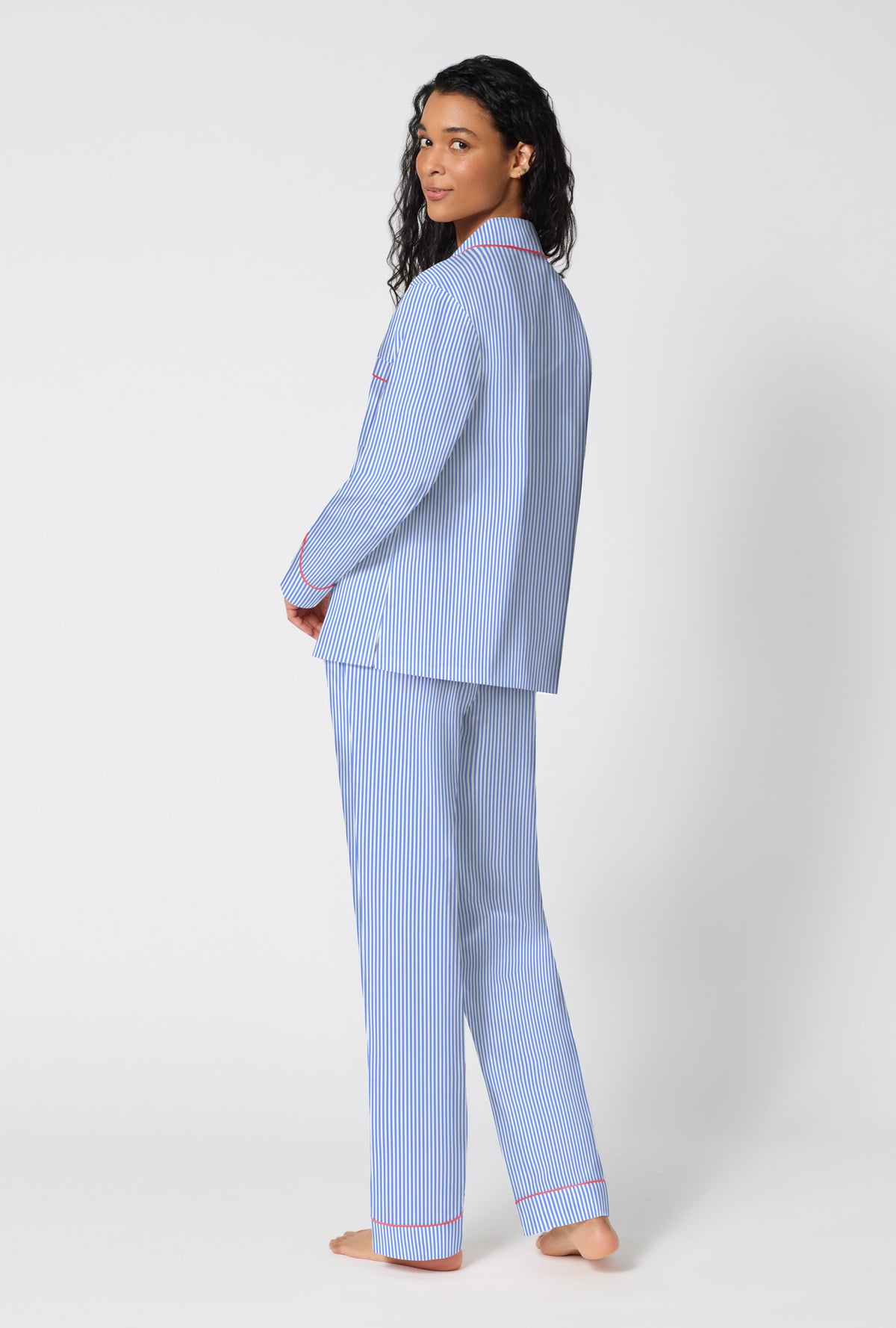 A Lady Wearing French Stripe Long Sleeve Classic Woven Supersoft Cotton Poplin Pj Set in a back view pose while looking back over the shoulder