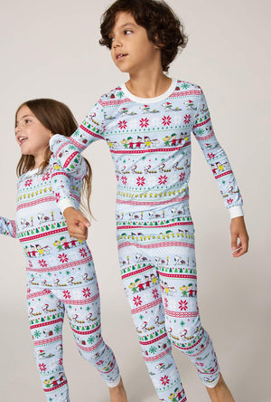 A boy and girl wearing Peanuts® Winter Parade Long Sleeve Stretch Jersey Kids Pj Set