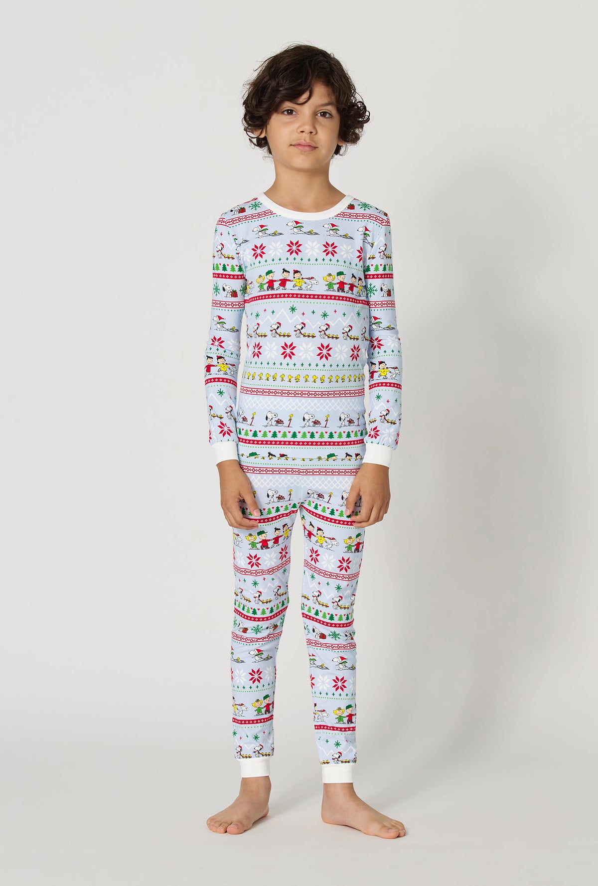 A boy wearing Peanuts® Winter Parade Long Sleeve Stretch Jersey Kids Pj Set
