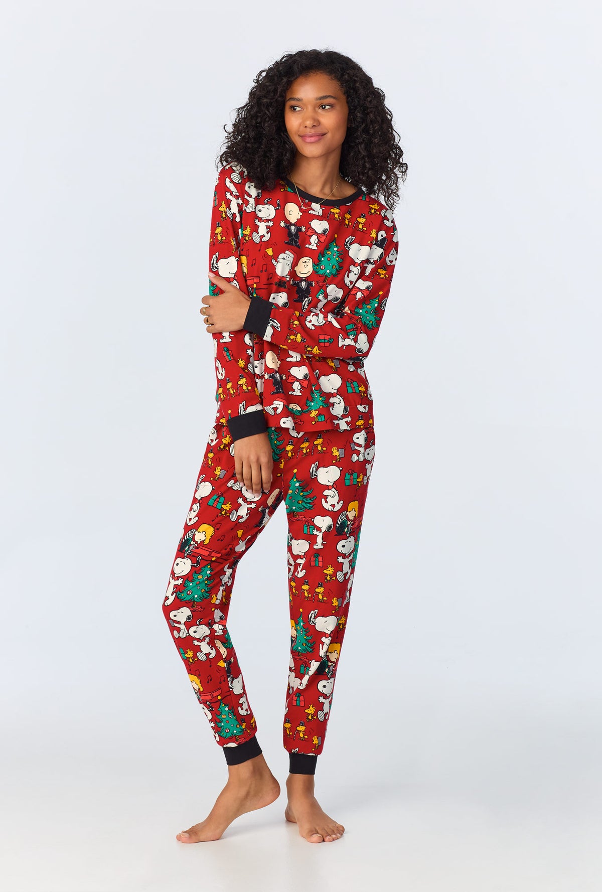 A lady wearing Peanut Festive Fun Long Sleeve Pullover Crew and Jogger Stretch Jersey PJ Set