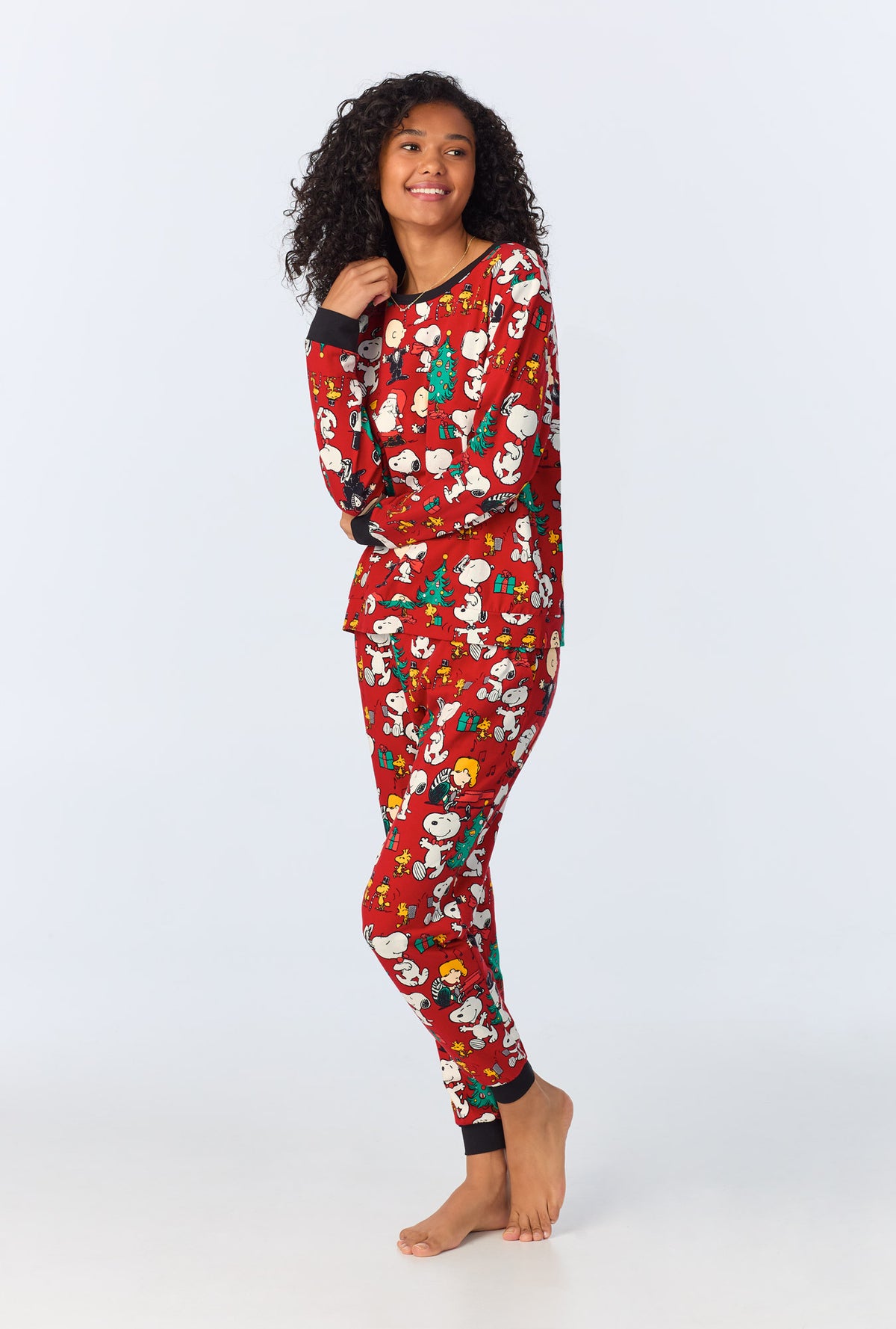 A lady wearing Peanut Festive Fun Long Sleeve Pullover Crew and Jogger Stretch Jersey PJ Set