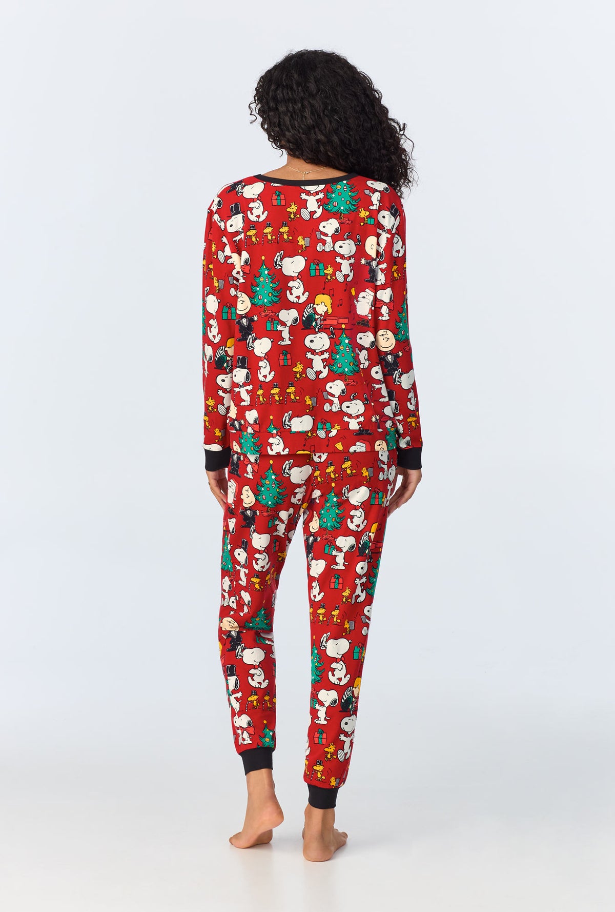 A lady wearing Peanut Festive Fun Long Sleeve Pullover Crew and Jogger Stretch Jersey PJ Set