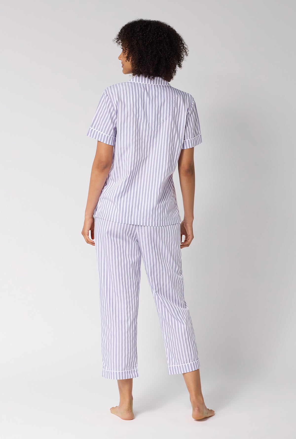 A Lady Wearing Blue Signature Stripe Short Sleeve Classic Woven Cotton Sateen Cropped Pj Set in a back view pose while looking to the side