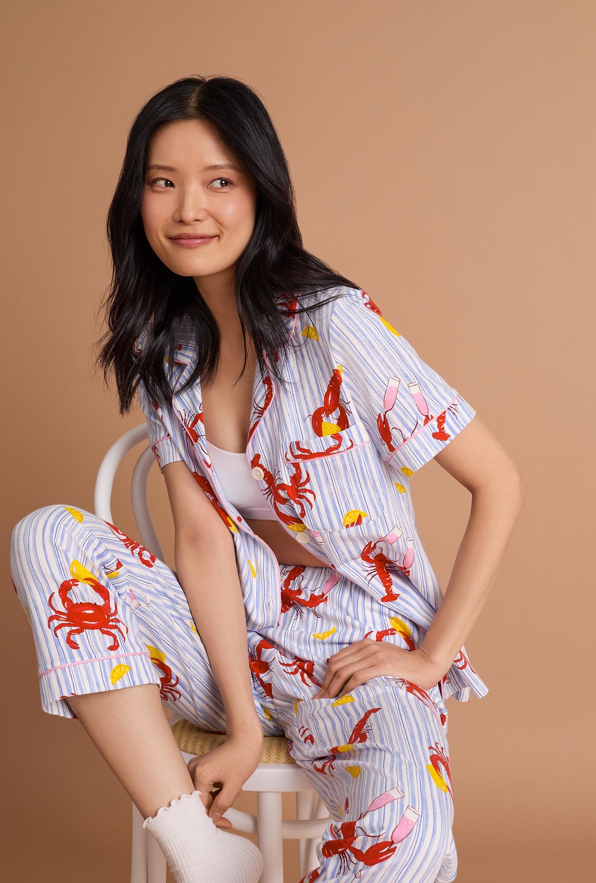  A lady wearing Coastal Feast Short Sleeve Classic Stretch Jersey Cropped Pj Set sitting 