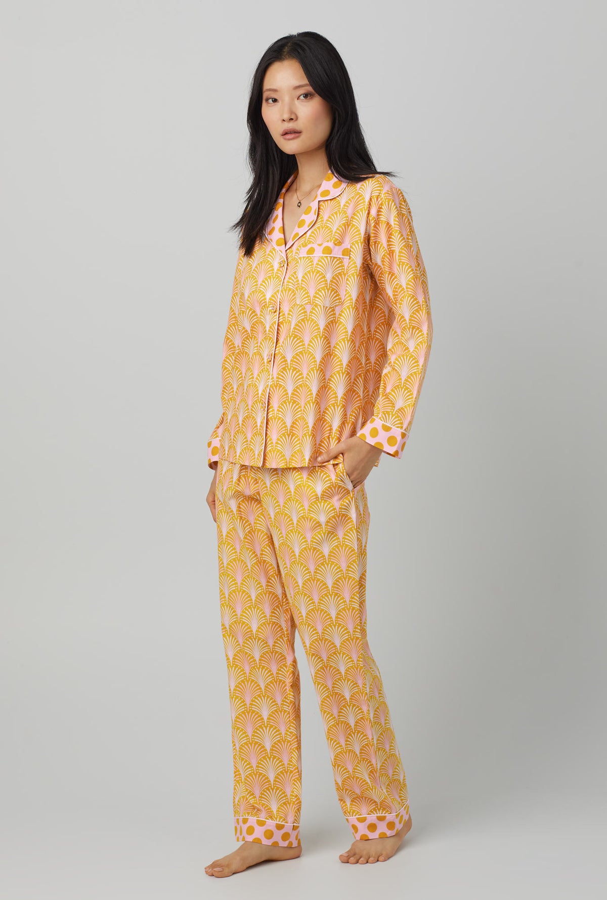 A lady wearing orange long sleeve classic woven cotton poplin pj set with suite life print