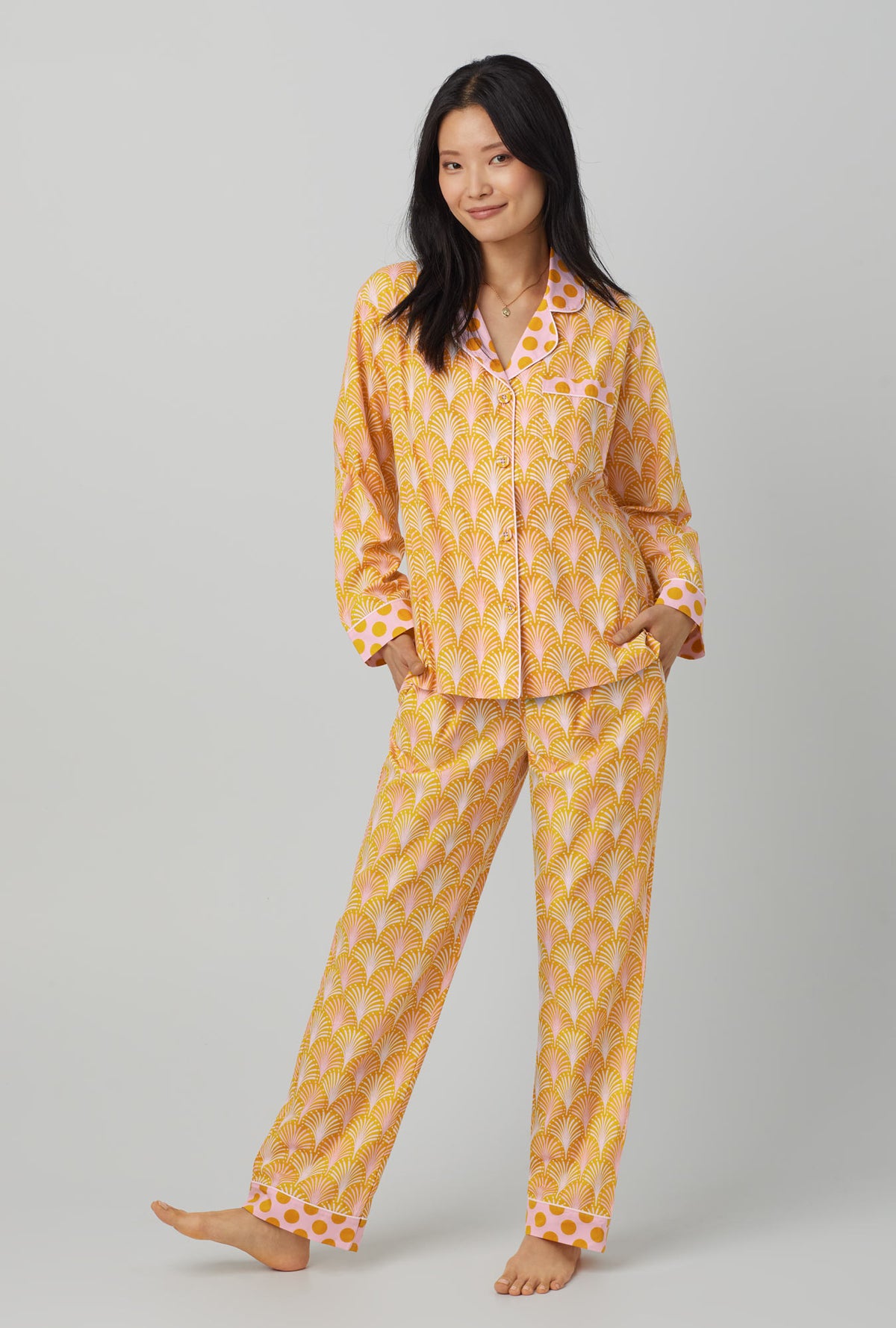 A lady wearing orange long sleeve classic woven cotton poplin pj set with suite life print
