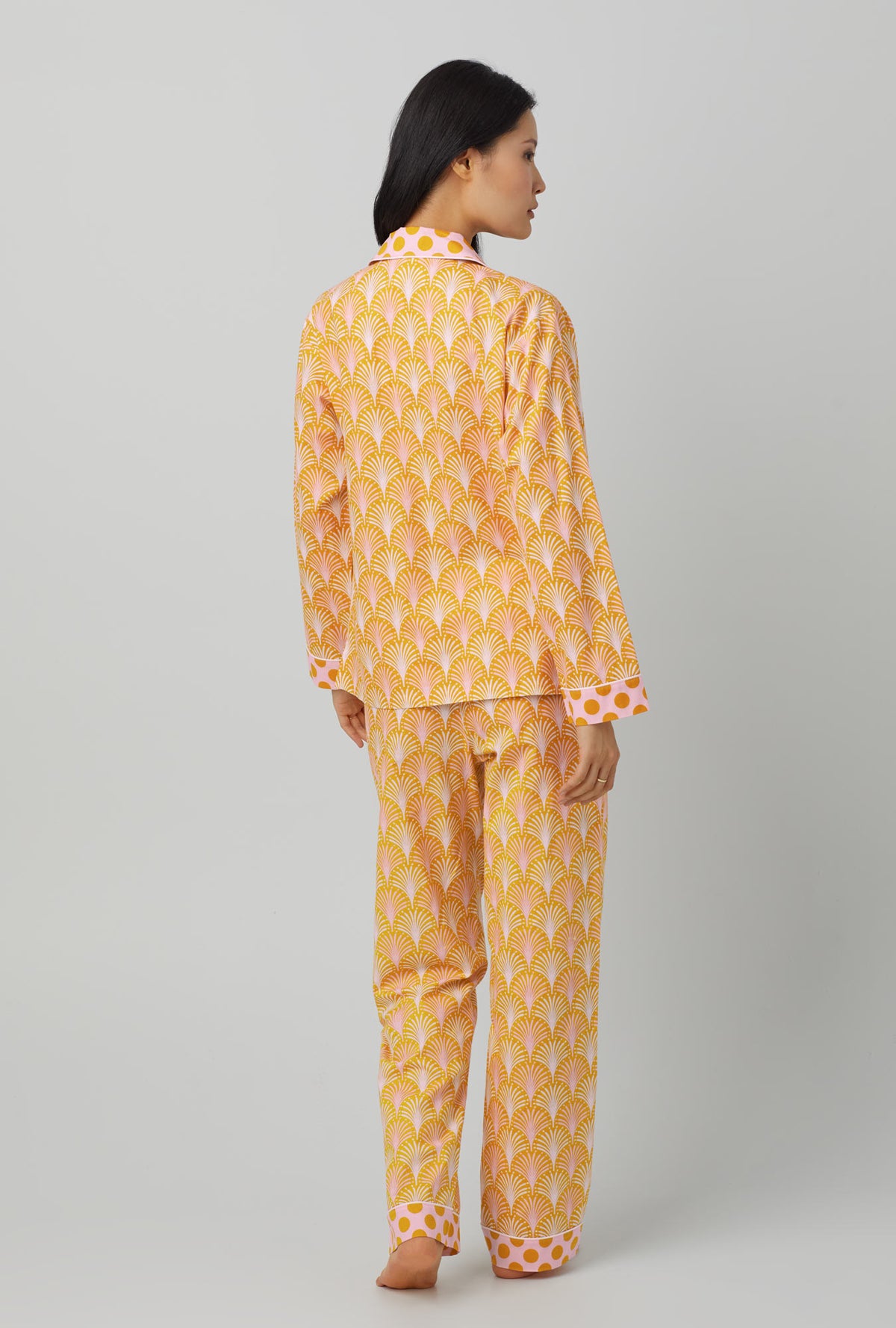 A lady wearing orange long sleeve classic woven cotton poplin pj set with suite life print