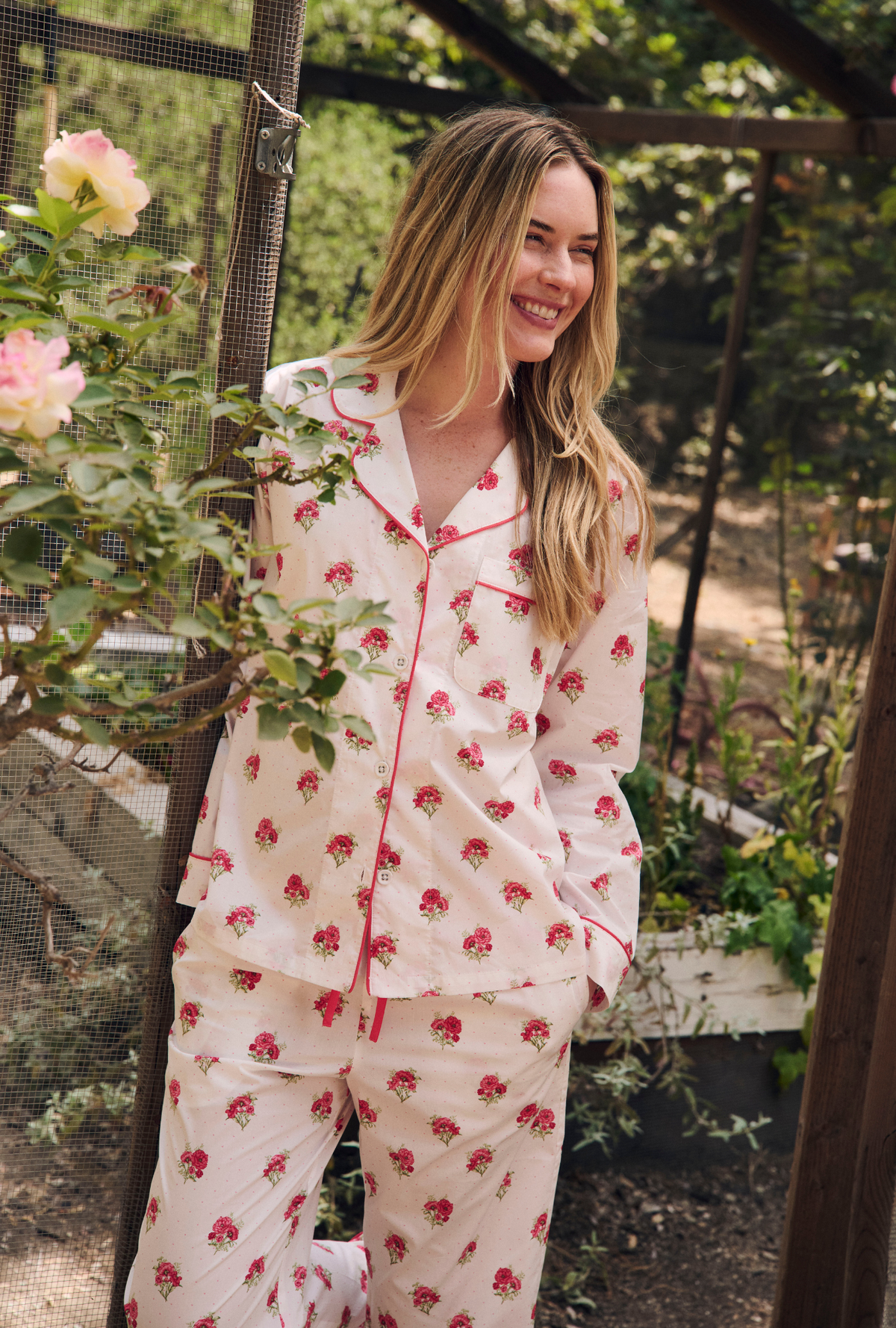 A Lady Wearing Celeste Long Sleeve Classic Woven Supersoft Cotton Poplin Pj Set standing and posing in a garden