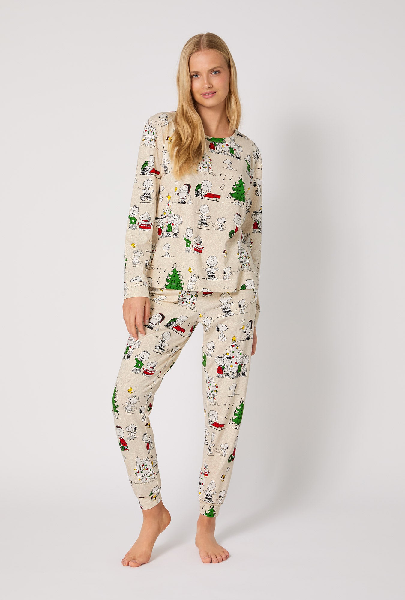 A lady wearing Peanuts® Celebration Long Sleeve Pullover Crew And Jogger Stretch Jersey Pj Set