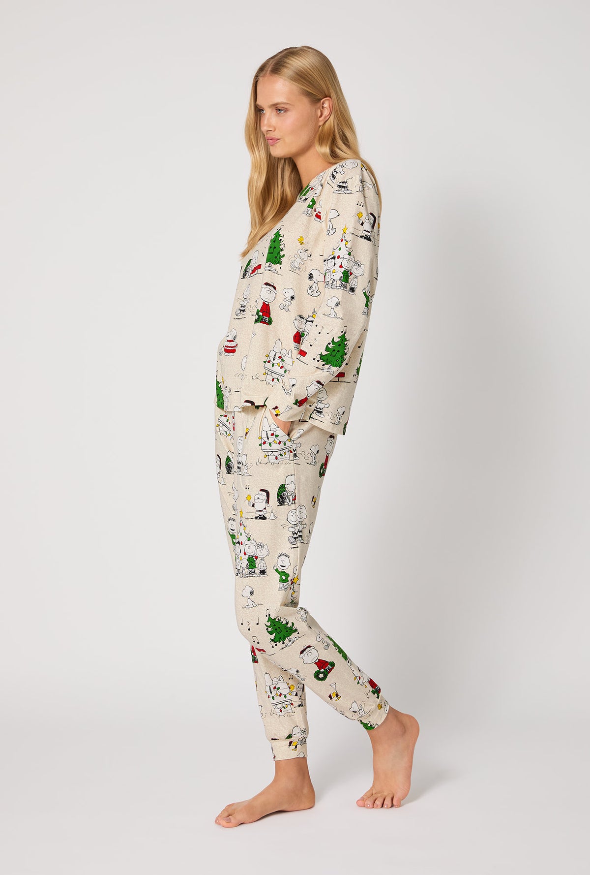 A lady wearing Peanuts® Celebration Long Sleeve Pullover Crew And Jogger Stretch Jersey Pj Set