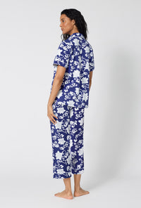 A Lady Wearing Dynasty Blue Short Sleeve Classic Stretch Jersey Cropped Pj Set in a back view side pose