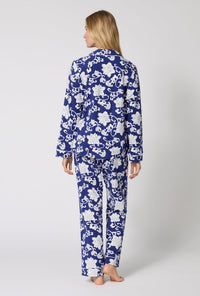A Lady Wearing Dynasty Blue Long Sleeve Classic Stretch Jersey Pj Set in a back view pose