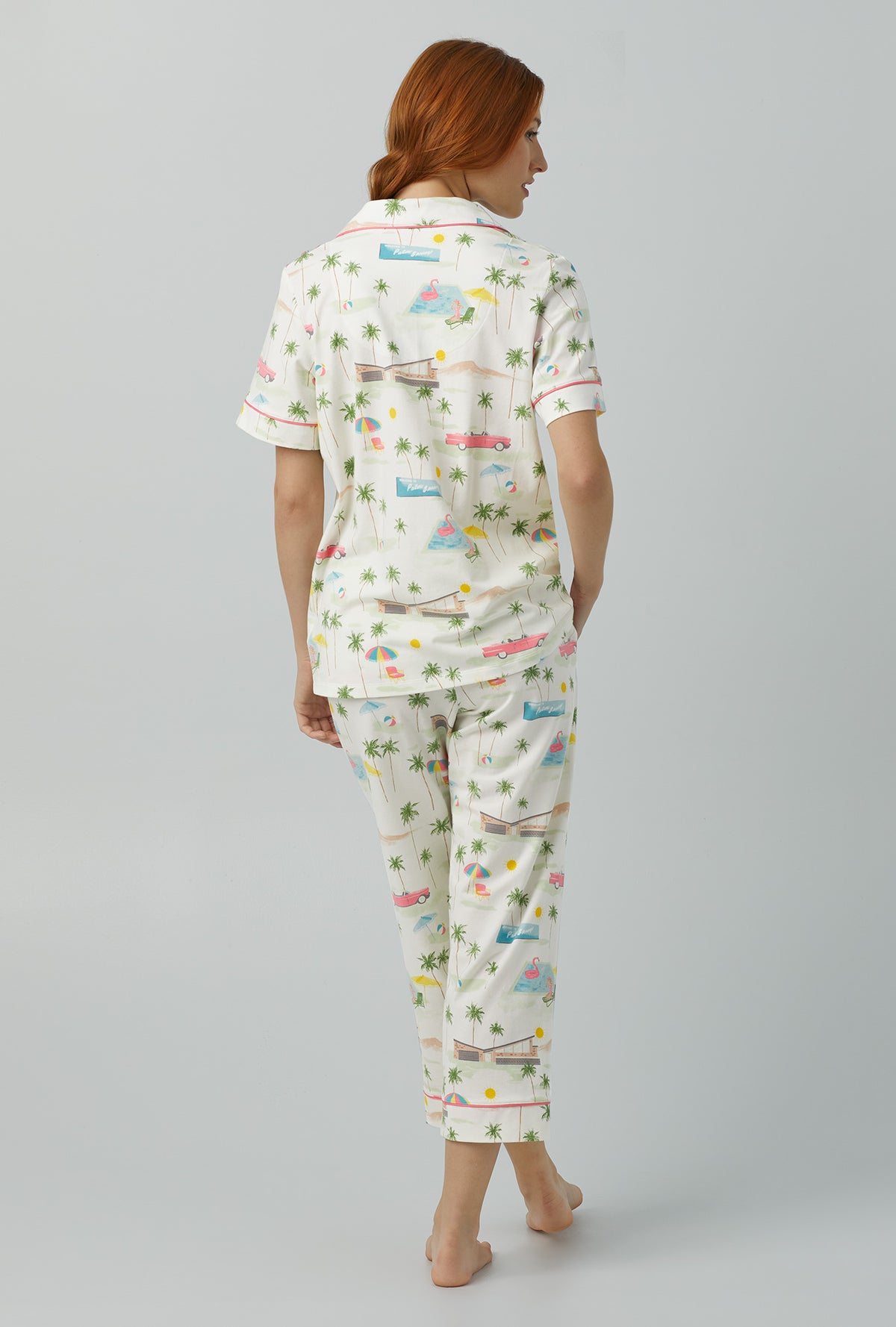 A lady wearing white Short Sleeve Classic Stretch Jersey Cropped PJ Set with Welcome to Palm Springs print