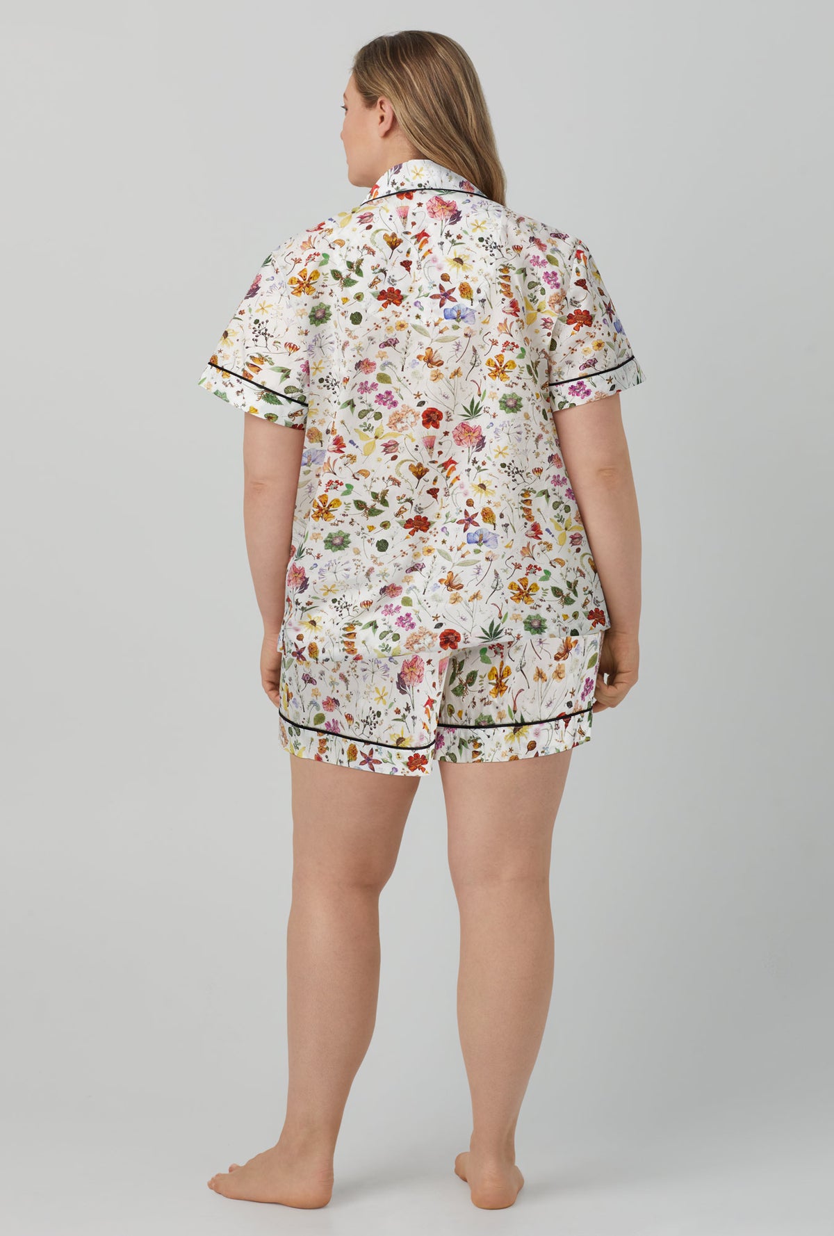 A lady wearing short sleeve classic short pj set with floral eve print