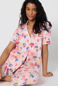 A Lady Wearing Serene Sunrise Short Sleeve Classic Stretch Jersey Cropped Pj Set in a close up sitting pose