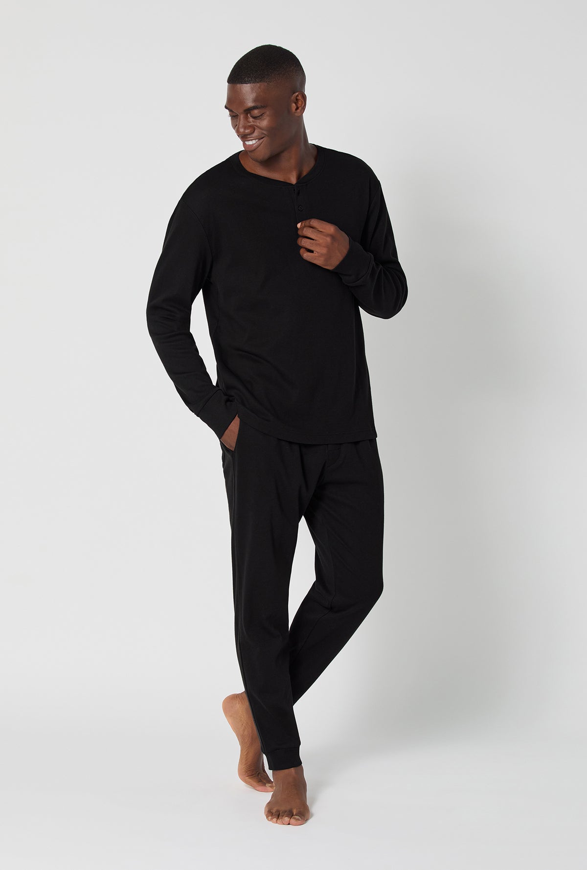 A man wearing Black Beauty Men&#39;s Long Sleeve Henley And Jogger Cotton Rib Pj Set