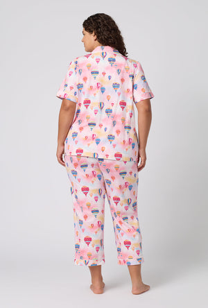 A Lady Wearing Plus Size Serene Sunrise Short Sleeve Classic Stretch Jersey Cropped Pj Set in a back view pose