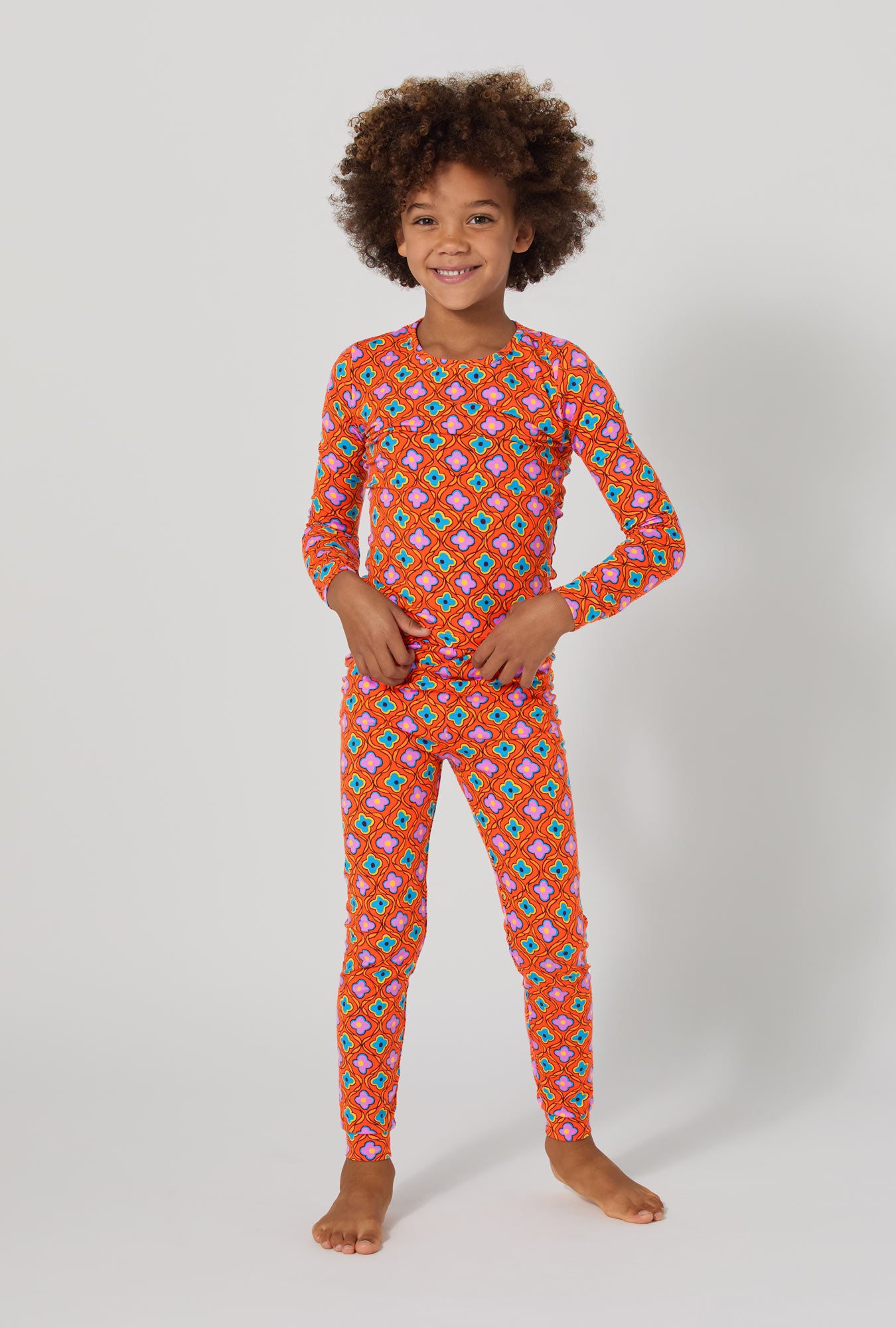 A boy wearing BedHead x Trina Turk Daisy Foulard Long Sleeve Stretch Jersey Kids Pj Set