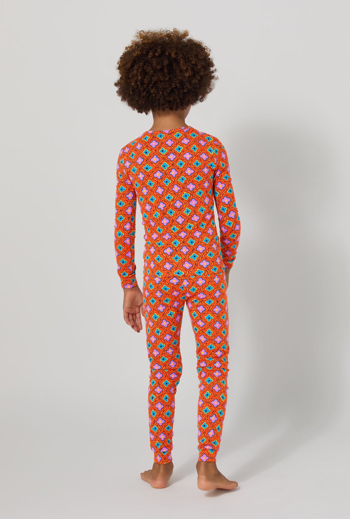 A girl wearing BedHead x Trina Turk Daisy Foulard Long Sleeve Stretch Jersey Kids Pj Set