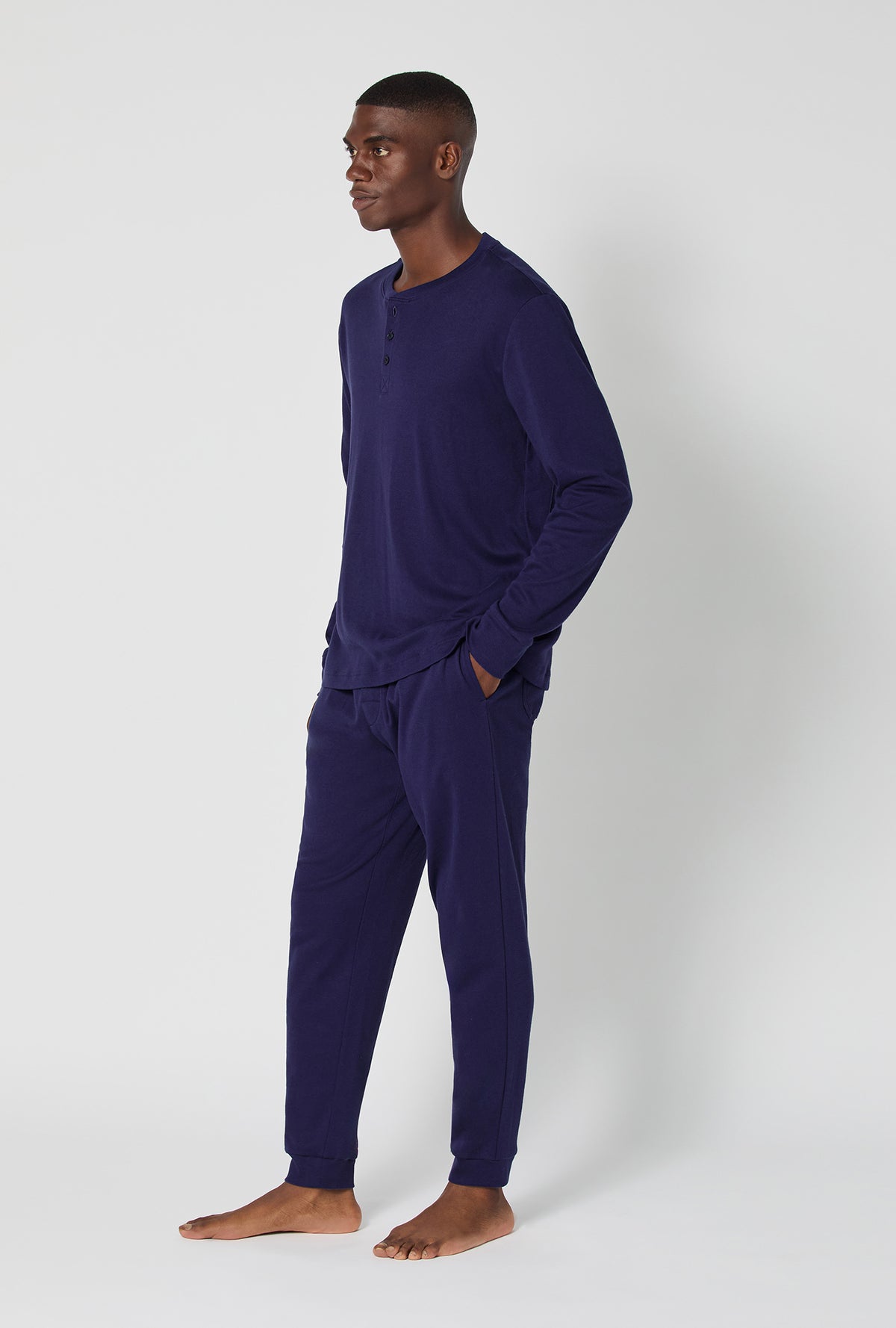 A man wearing Midnight Navy Men's Long Sleeve Henley And Jogger Cotton Rib Pj Set
