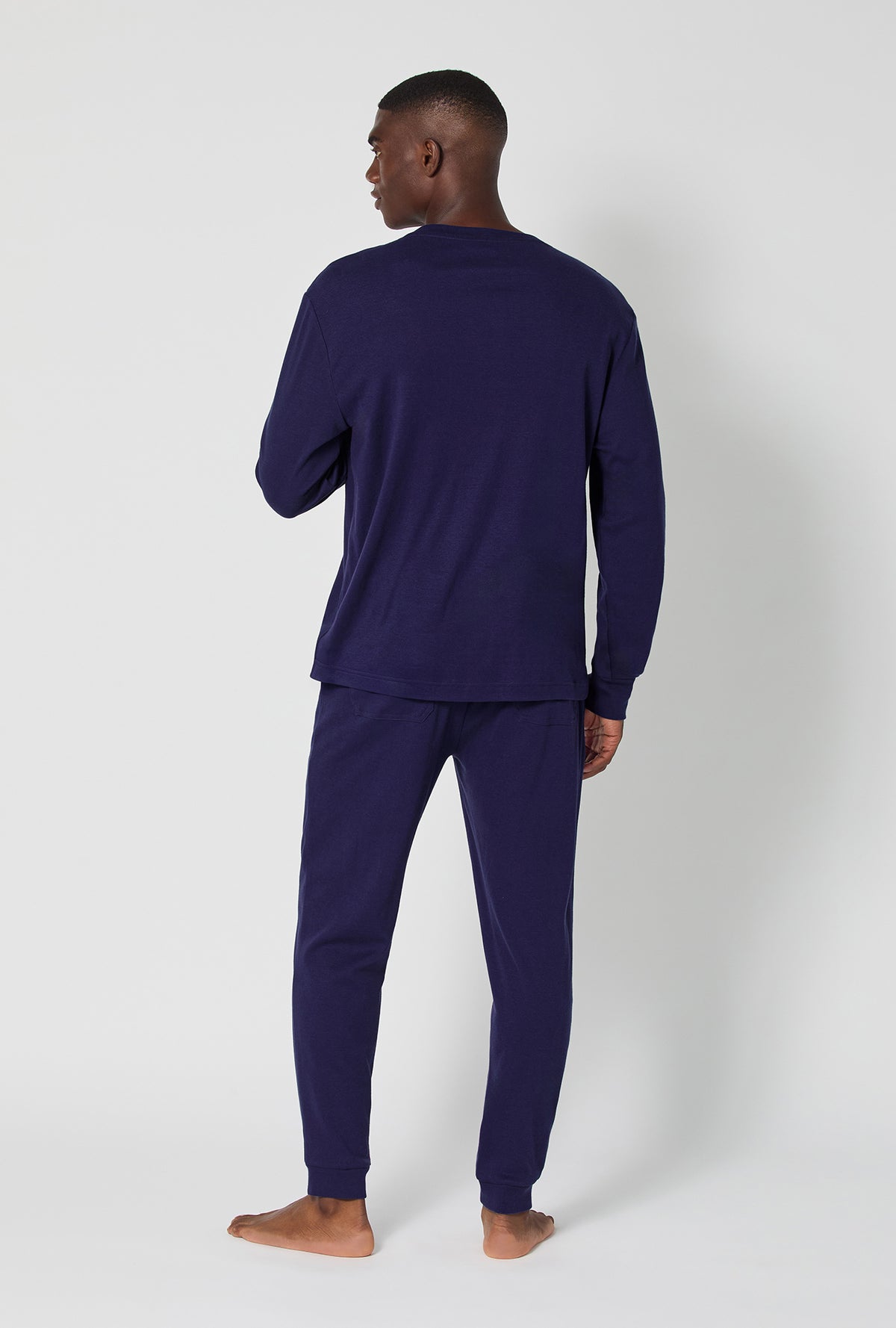 A man wearing Midnight Navy Men's Long Sleeve Henley And Jogger Cotton Rib Pj Set