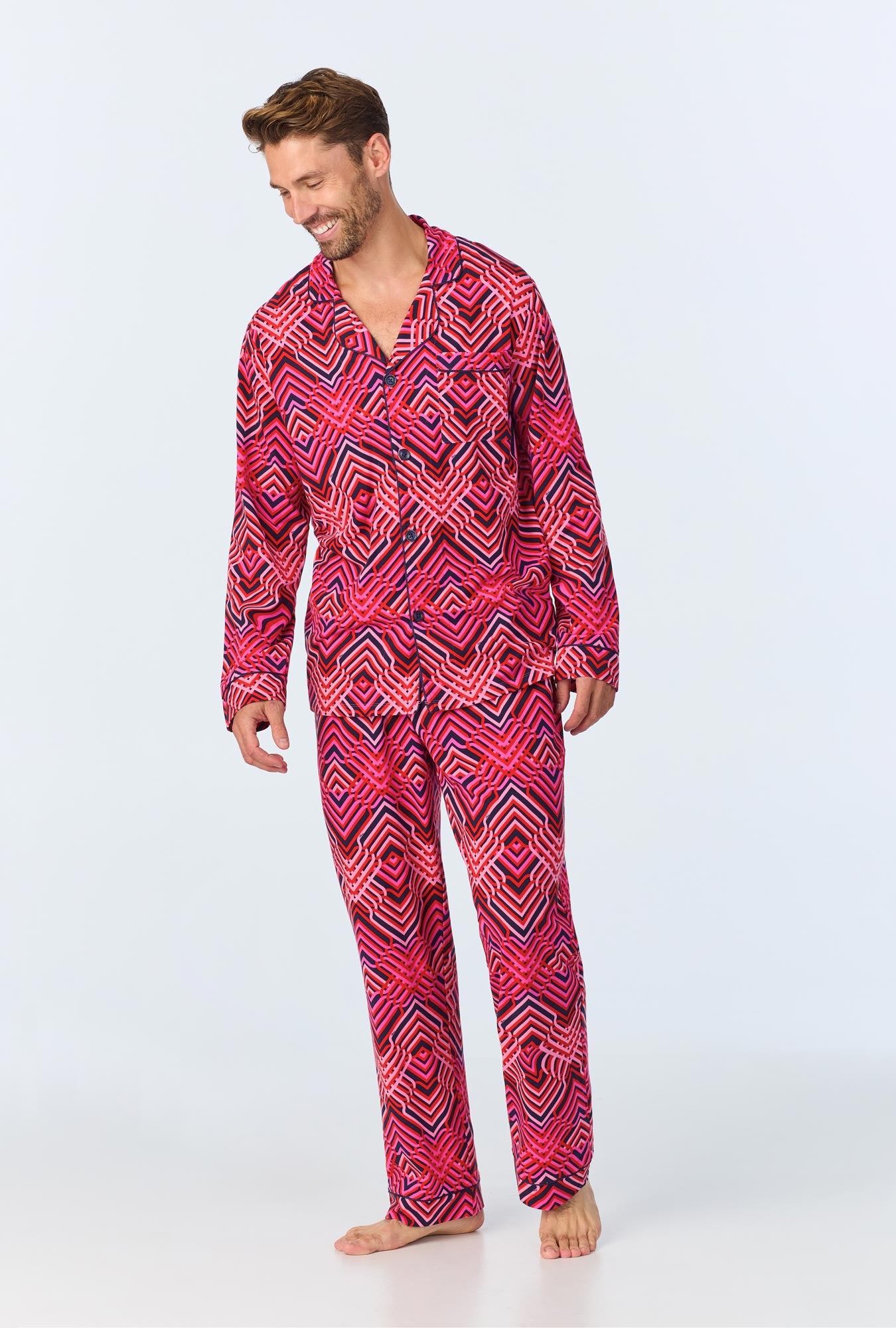 A man wearing multi color long sleeve notch collar pj set with geo trellis print.