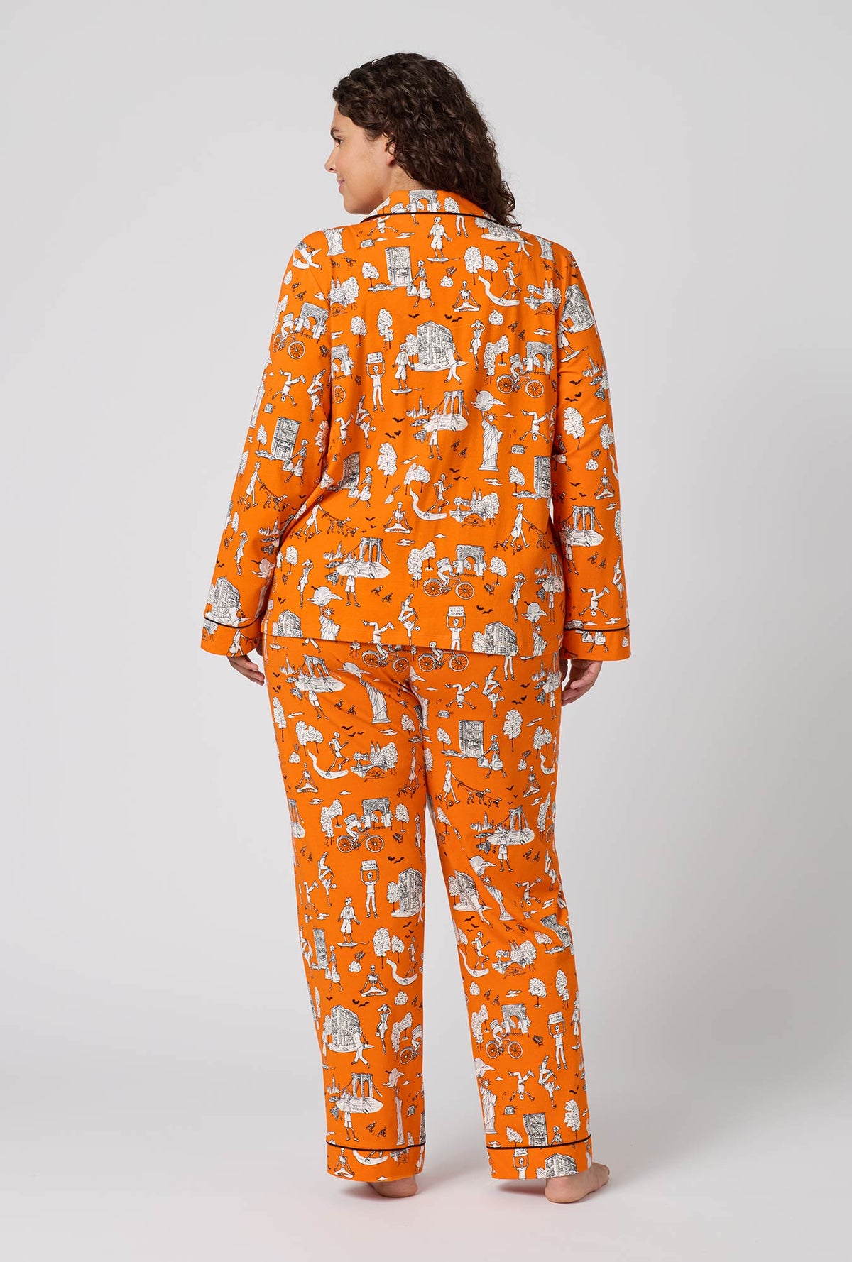 A Lady Wearing Plus Size Orange Spooky In The City Long Sleeve Classic Stretch Jersey Pj Set in a back view pose