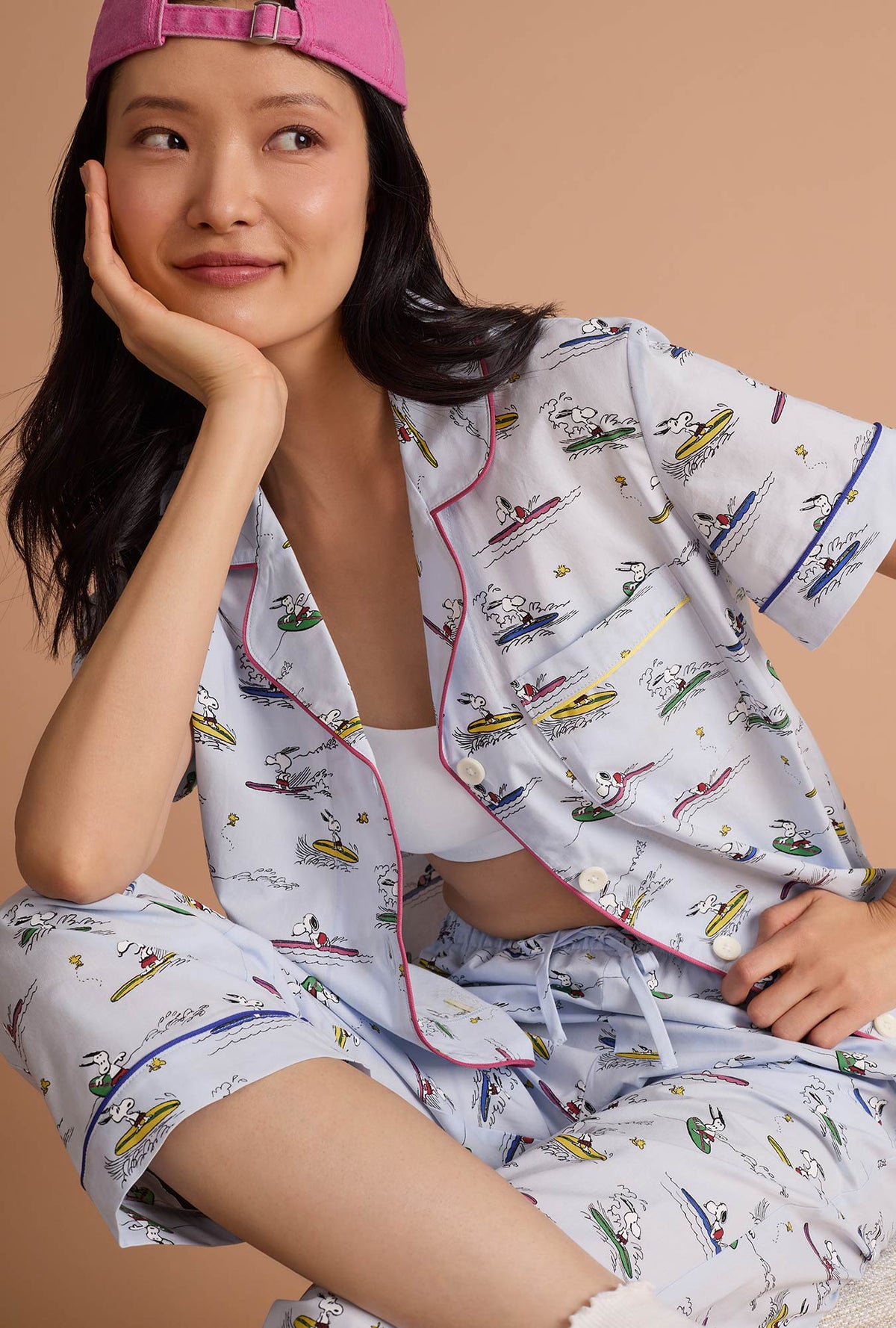 A lady wearing Catch A Wave Snoopy Short Sleeve Classic Woven Cotton Poplin Cropped Pj Set sitting down