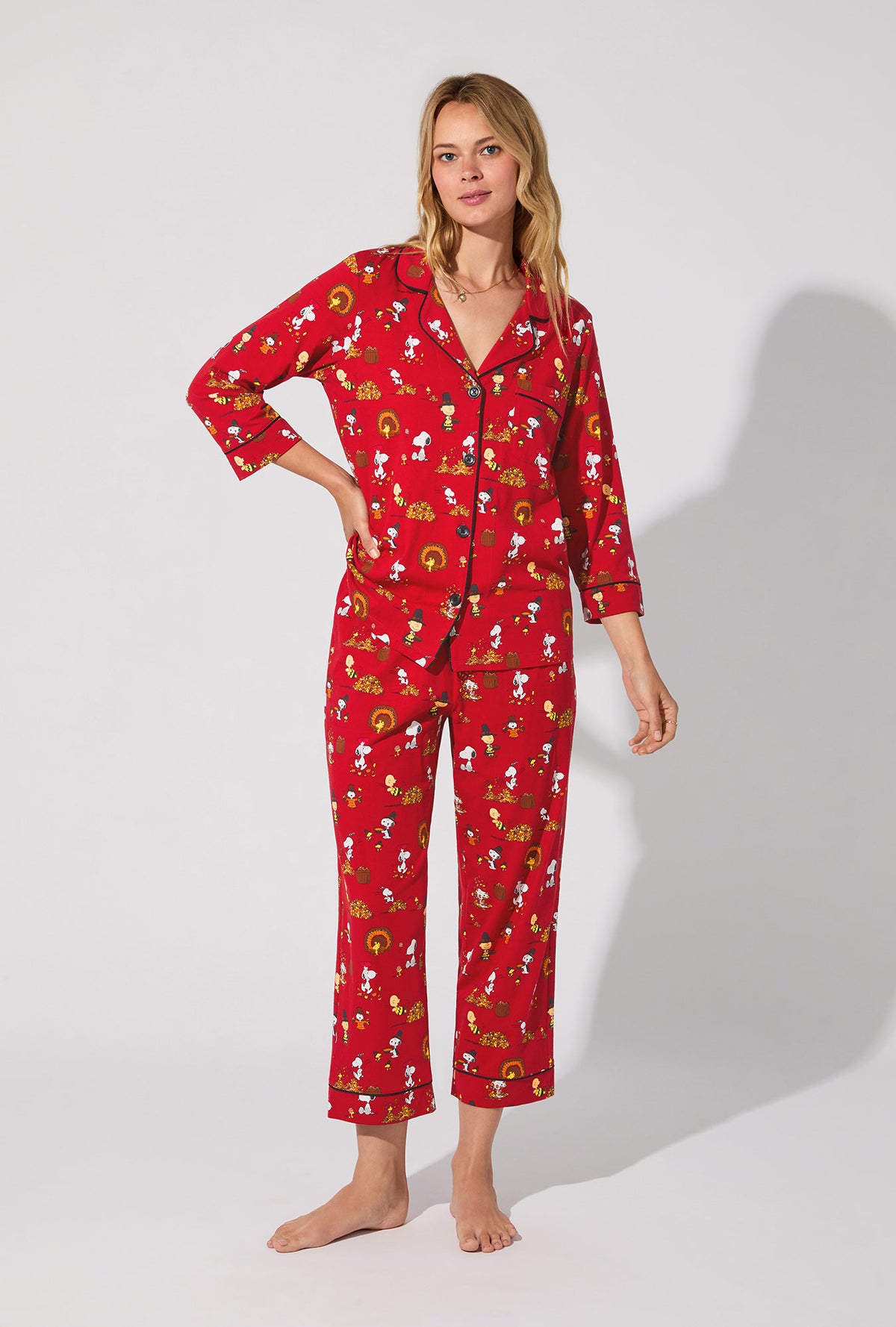 A lady wearing Peanuts® Snoopy&#39;s Thanksgiving  3/4 Sleeve Classic Stretch Jersey Cropped PJ Set