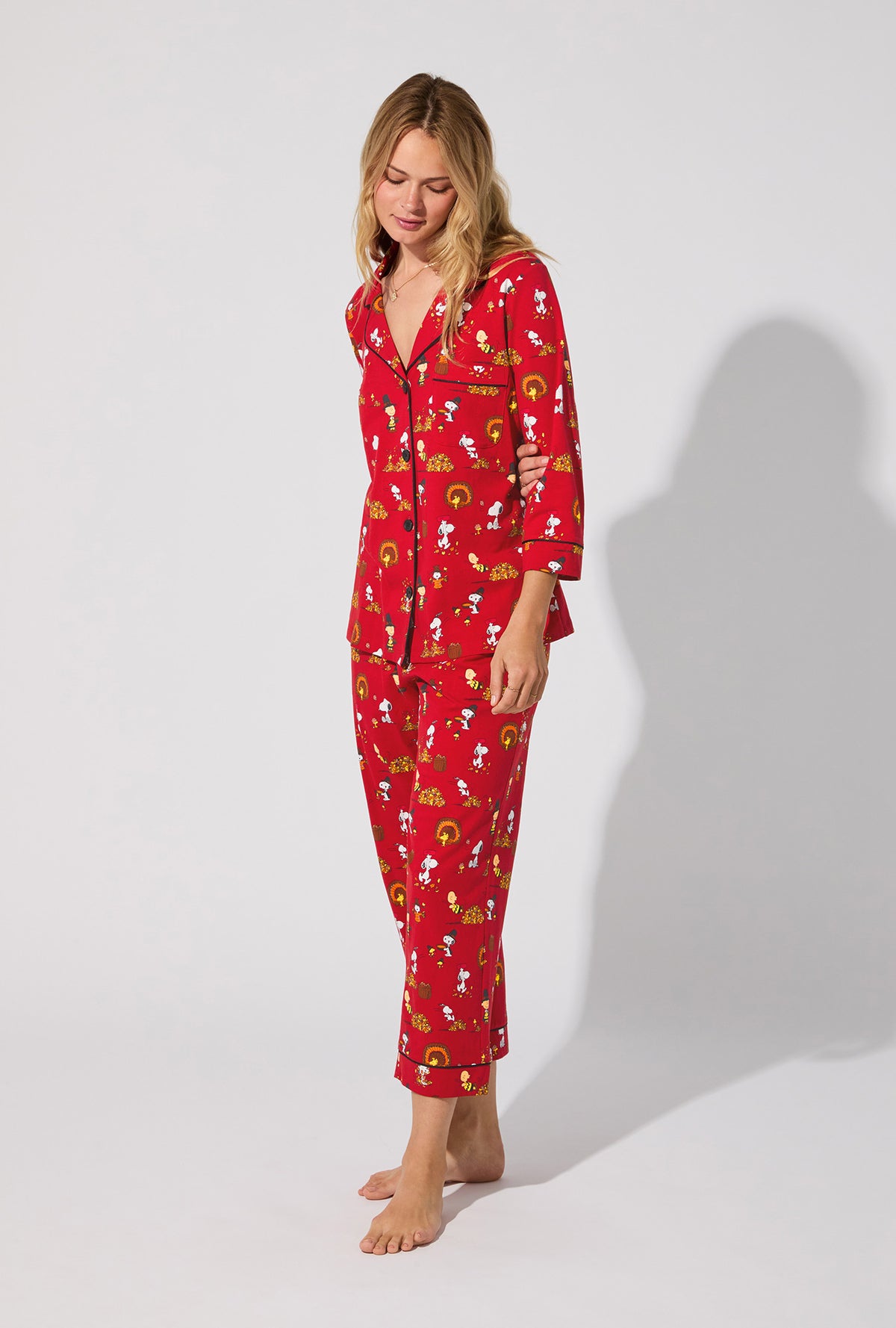 A lady wearing Peanuts® Snoopy&#39;s Thanksgiving  3/4 Sleeve Classic Stretch Jersey Cropped PJ Set