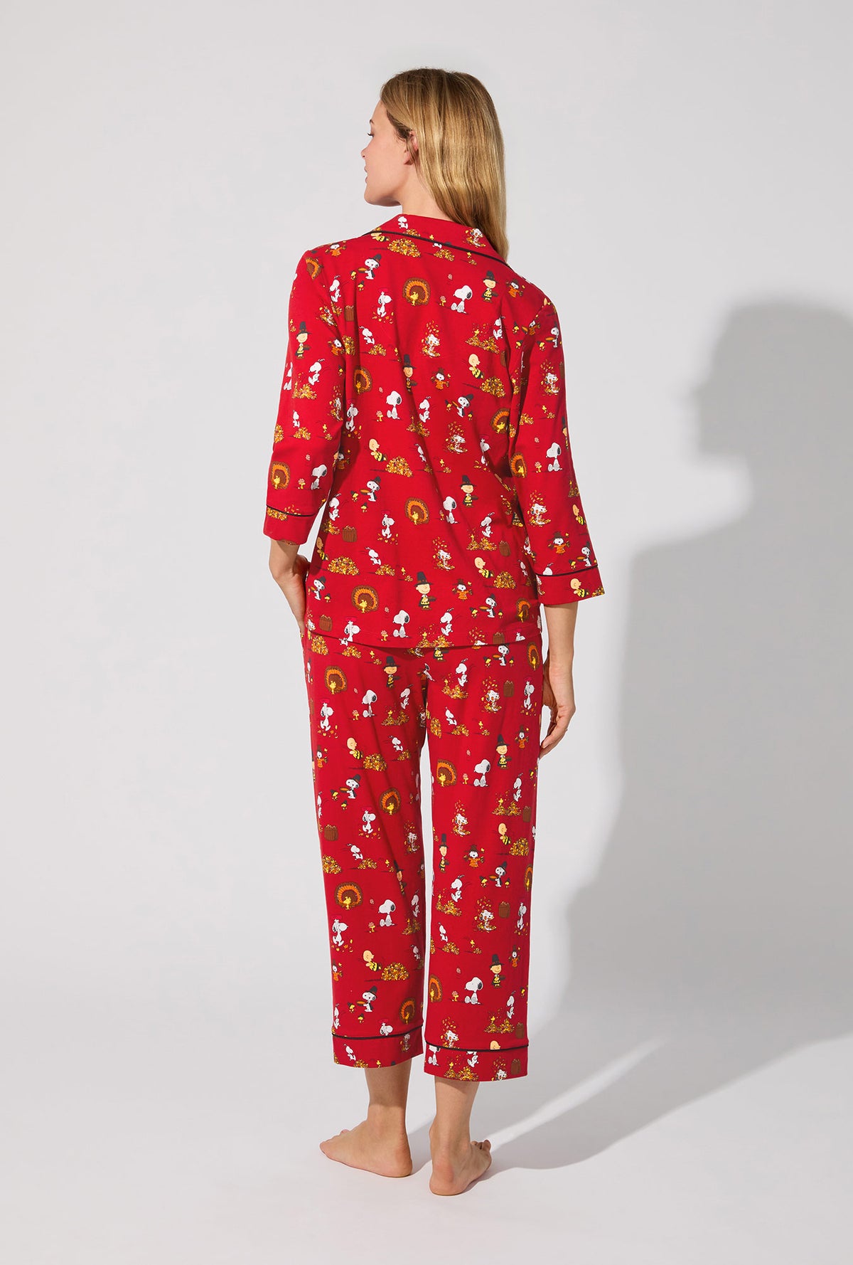 A lady wearing Peanuts® Snoopy&#39;s Thanksgiving  3/4 Sleeve Classic Stretch Jersey Cropped PJ Set