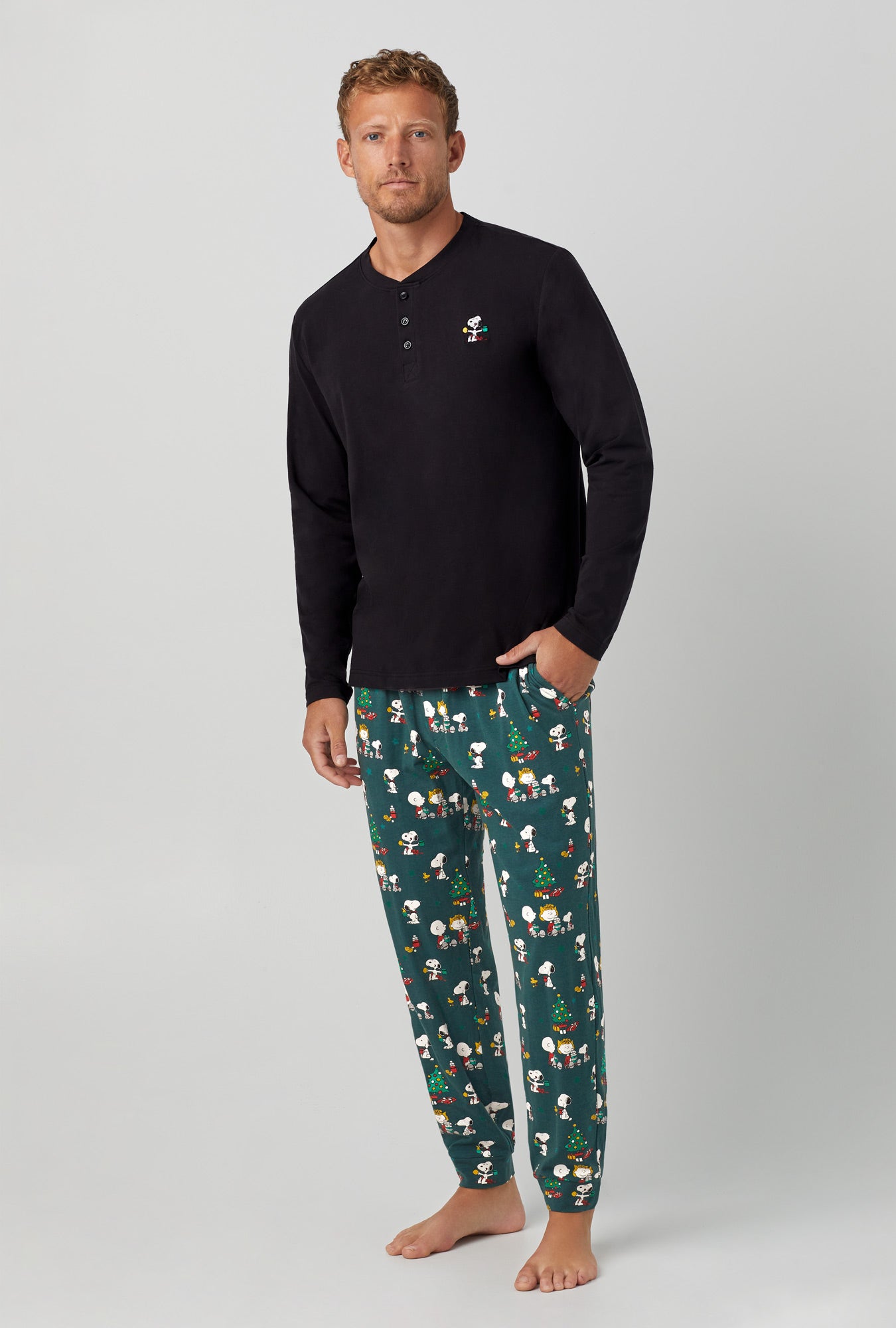 A man wearing black  Henley and Jogger Stretch Jersey PJ Set with Snoopy's Cocoa  print