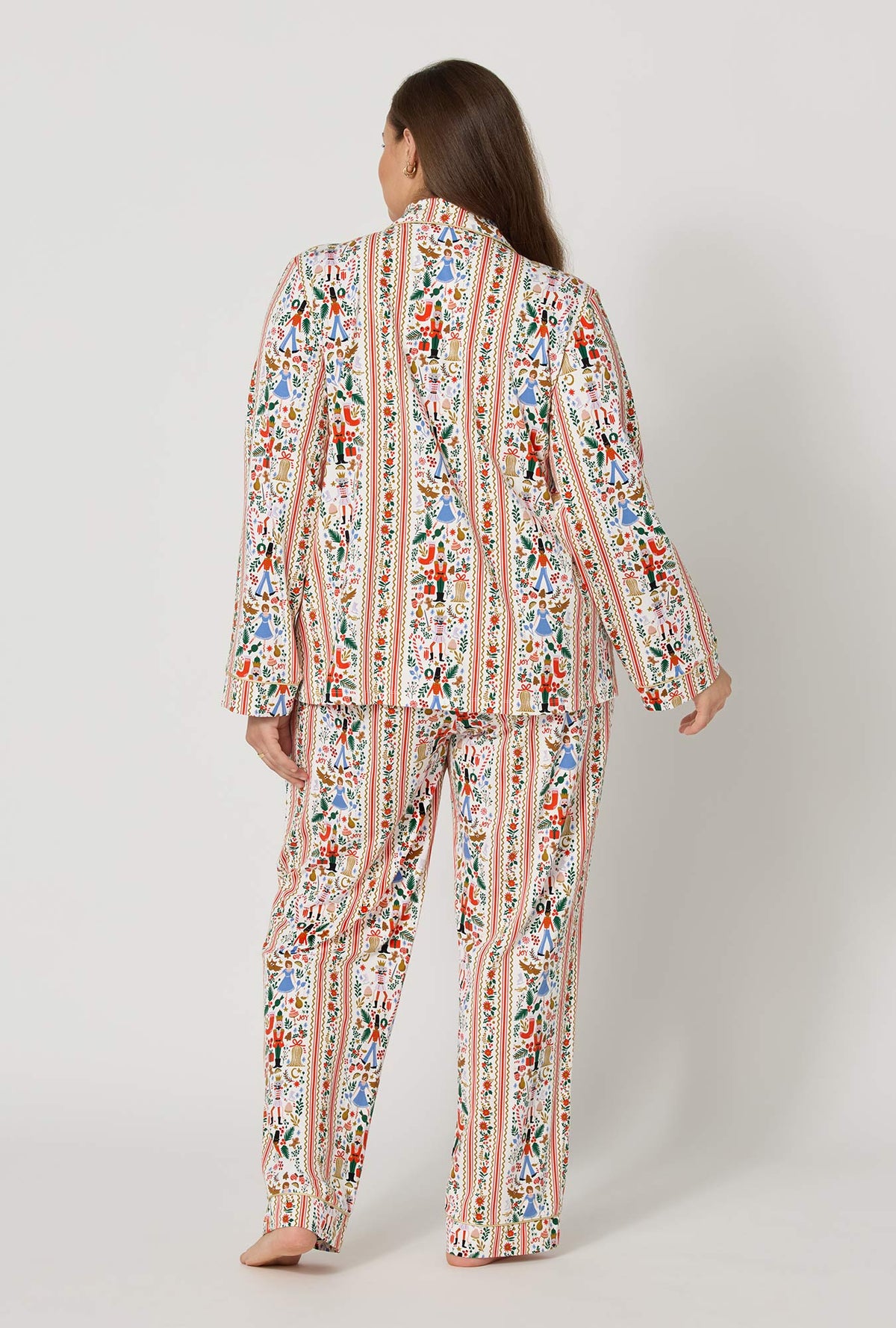 A lady wearing plus size Rifle Paper Co. x BedHead PJs Holly Jolly Nutcracker Long Sleeve Classic Stretch Jersey Pj Set back view