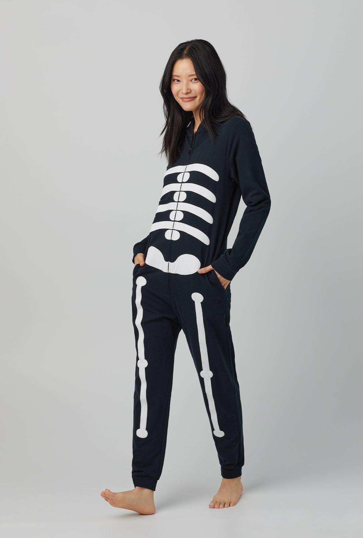 A lady wearing unisex long sleeve french terry onesie with skeleton print