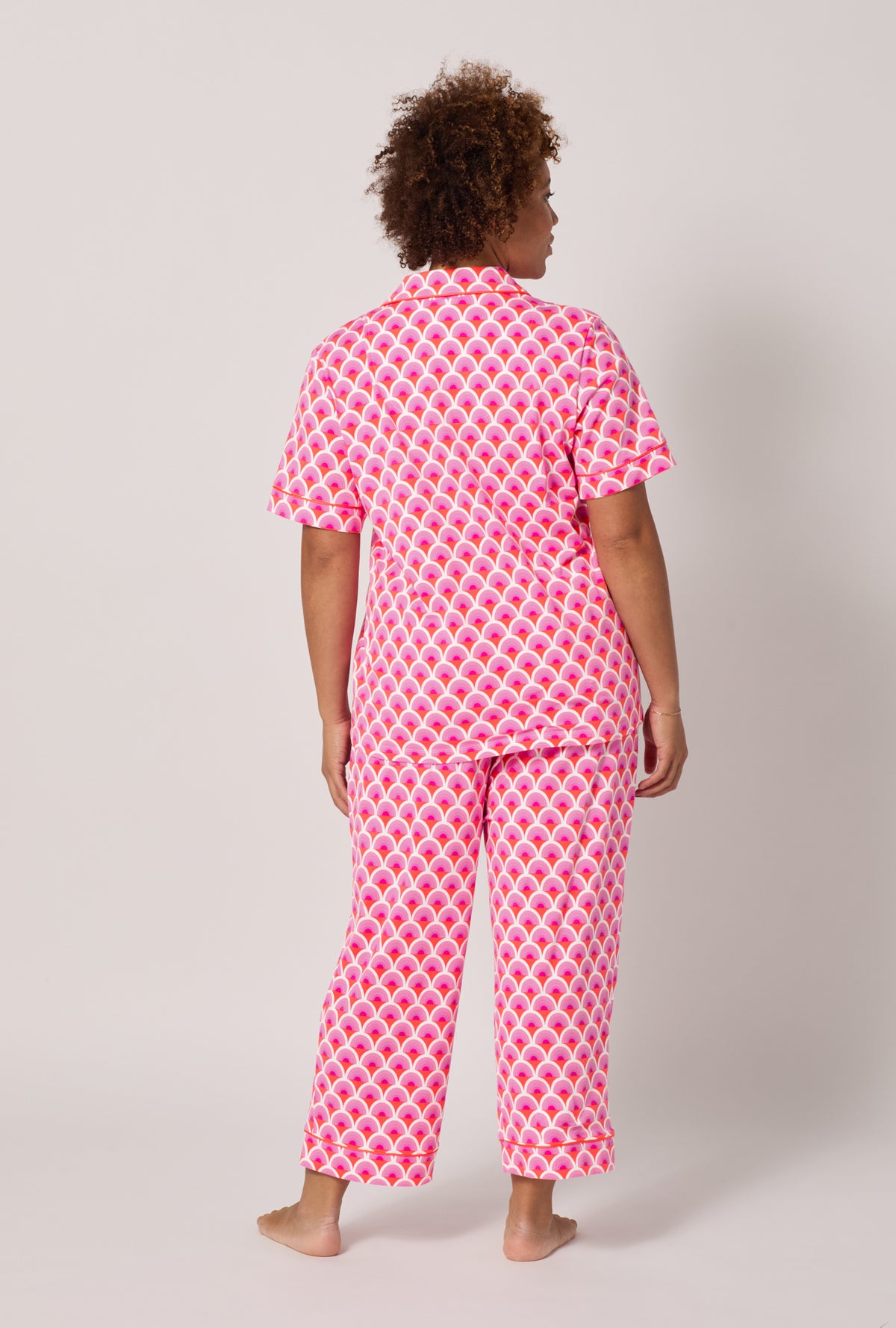 A lady wearing plus size BedHead x Trina Turk Scallop Short Sleeve Classic Stretch Jersey Cropped Pj Set