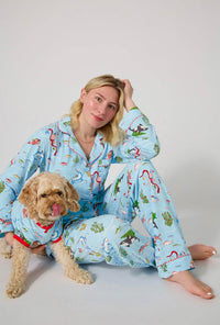 A dog wearing Jingle All The Wave Stretch Jersey Dog Pajama with a lady 