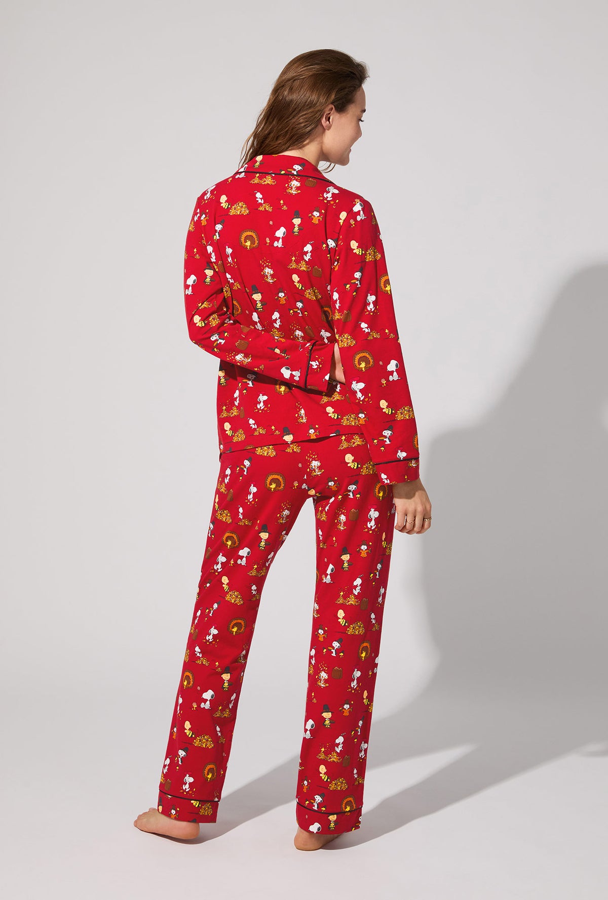 A lady wearing Peanuts® Snoopy&#39;s Thanksgiving Long Sleeve Classic Stretch Jersey PJ Set